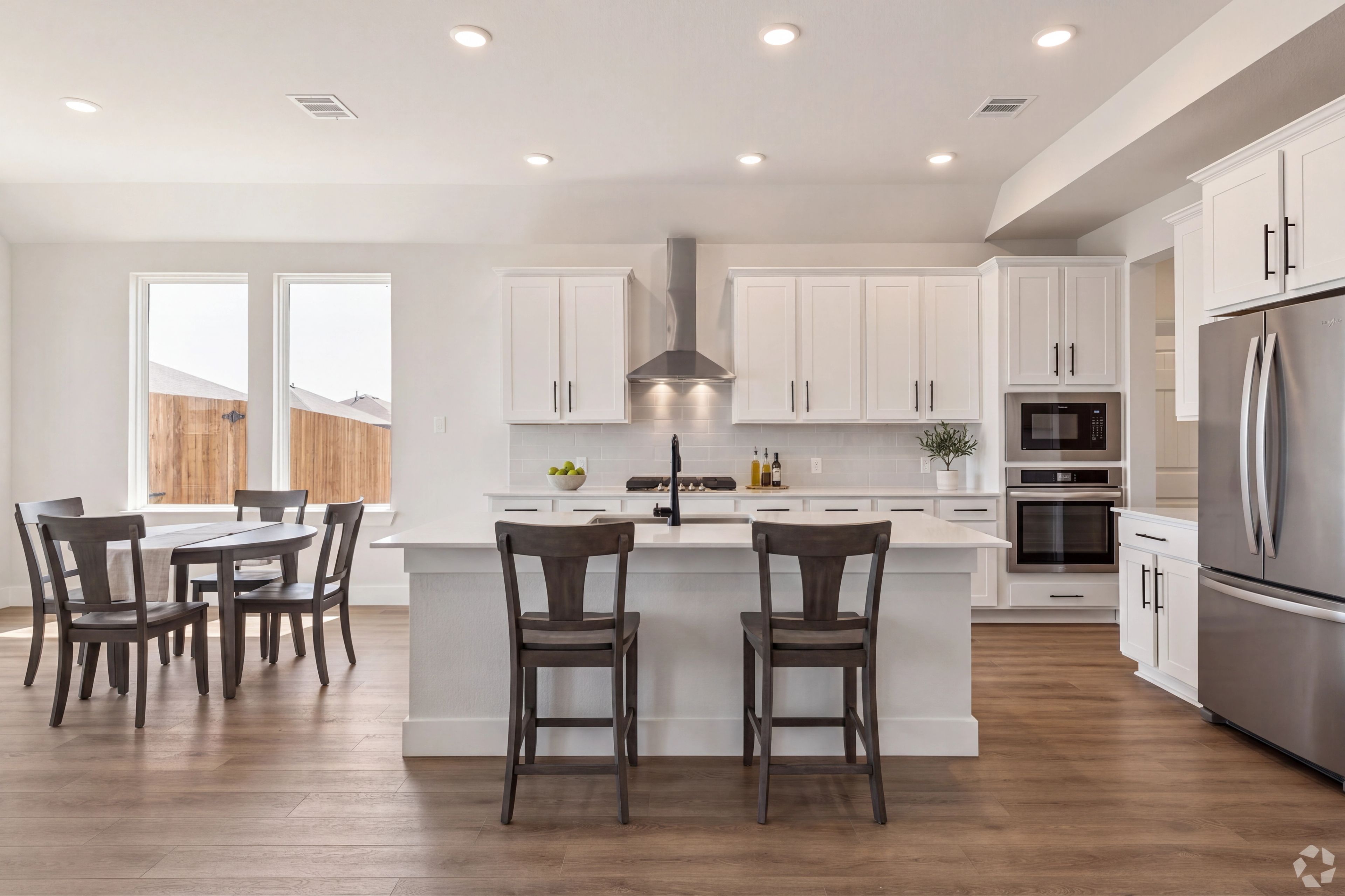 open concept kitchen with white cabinets, stainless appliances and large island