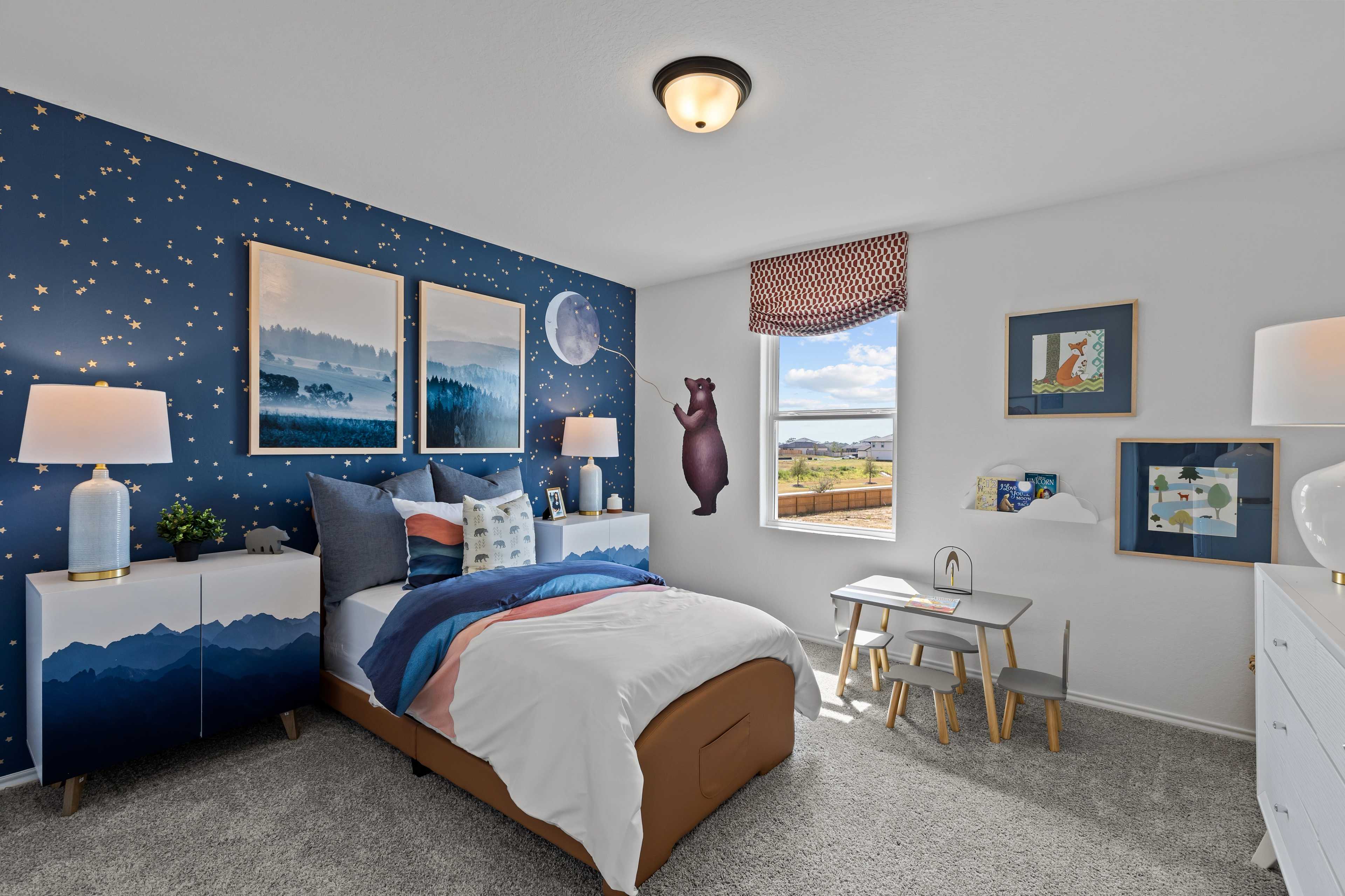 Cozy kids bedroom at Hickory Ridge in Elmendorf TX featuring starry blue walls, twin bed, desk, and bear decal