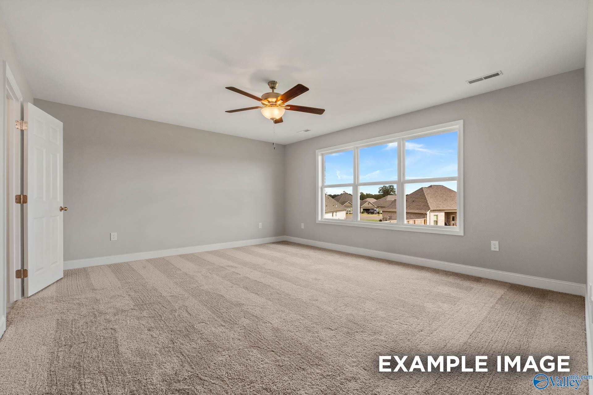 Bright bedroom with gray walls, carpet flooring, ceiling fan, and large windows overlooking neighborhood in Davidson Homes Shelby B, New Market, Alabama