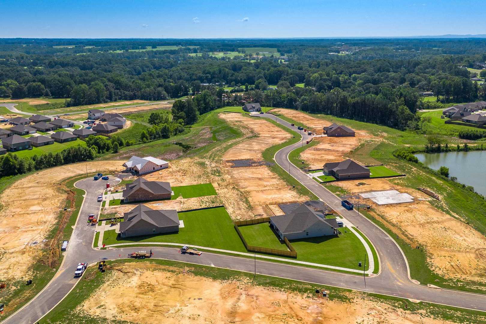 Aerial view of North Ridge in Cullman Alabama showcasing new Davidson Homes under construction with pond and wooded lots