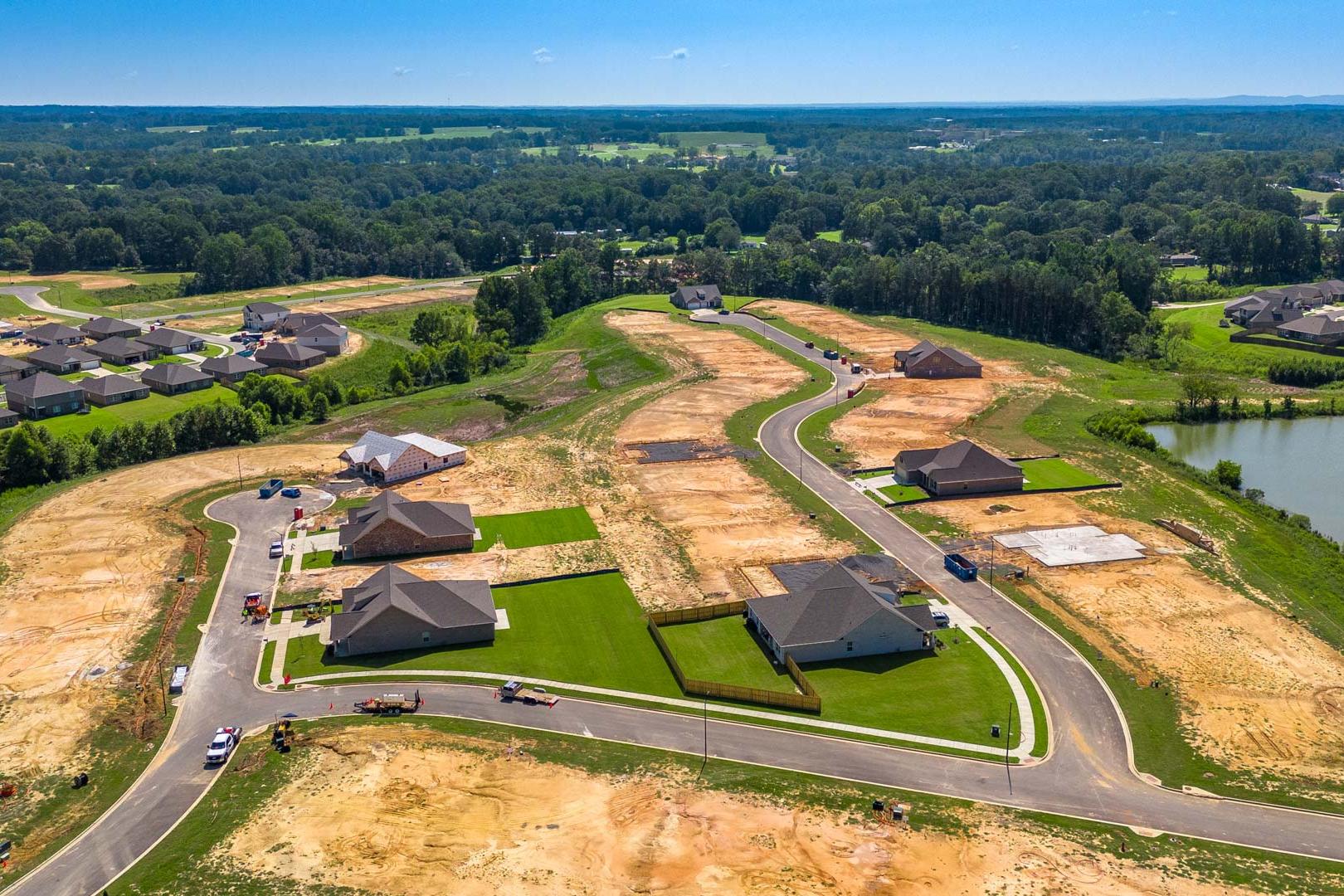 Aerial view of North Ridge in Cullman Alabama showcasing new Davidson Homes under construction with pond and wooded lots