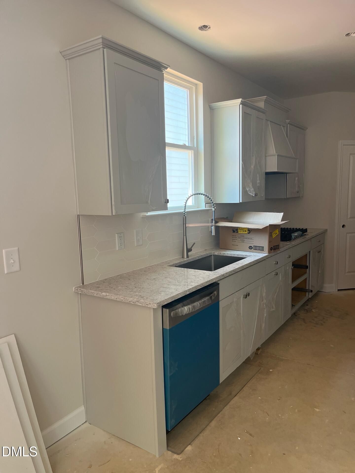 Modern white shaker kitchen with granite counters, high-arc faucet, and dishwasher in Davidson Homes The Ashport G, Wake Forest, NC