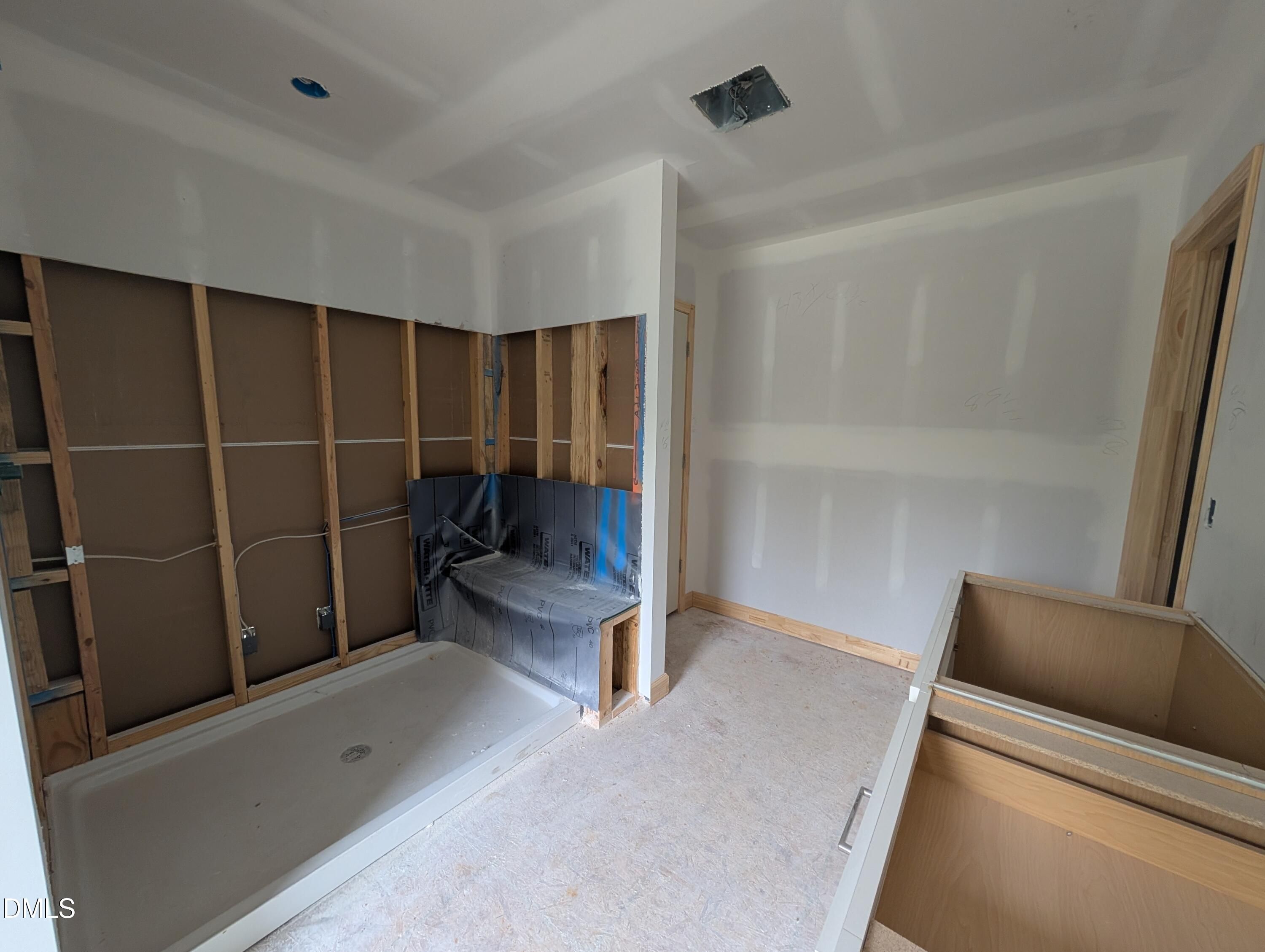 Master bathroom under construction with walk-in shower base and unfinished drywall in Davidson Homes The Beech, Wendell Ridge