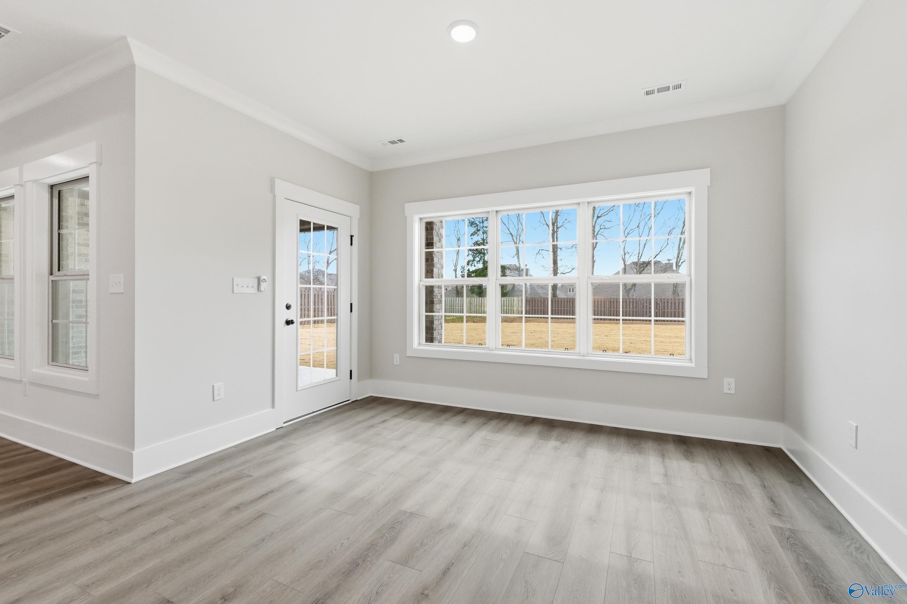Bright sunroom with large triple windows and French door overlooking yard in Davidson Homes The Finleigh, Meridianville, Alabama