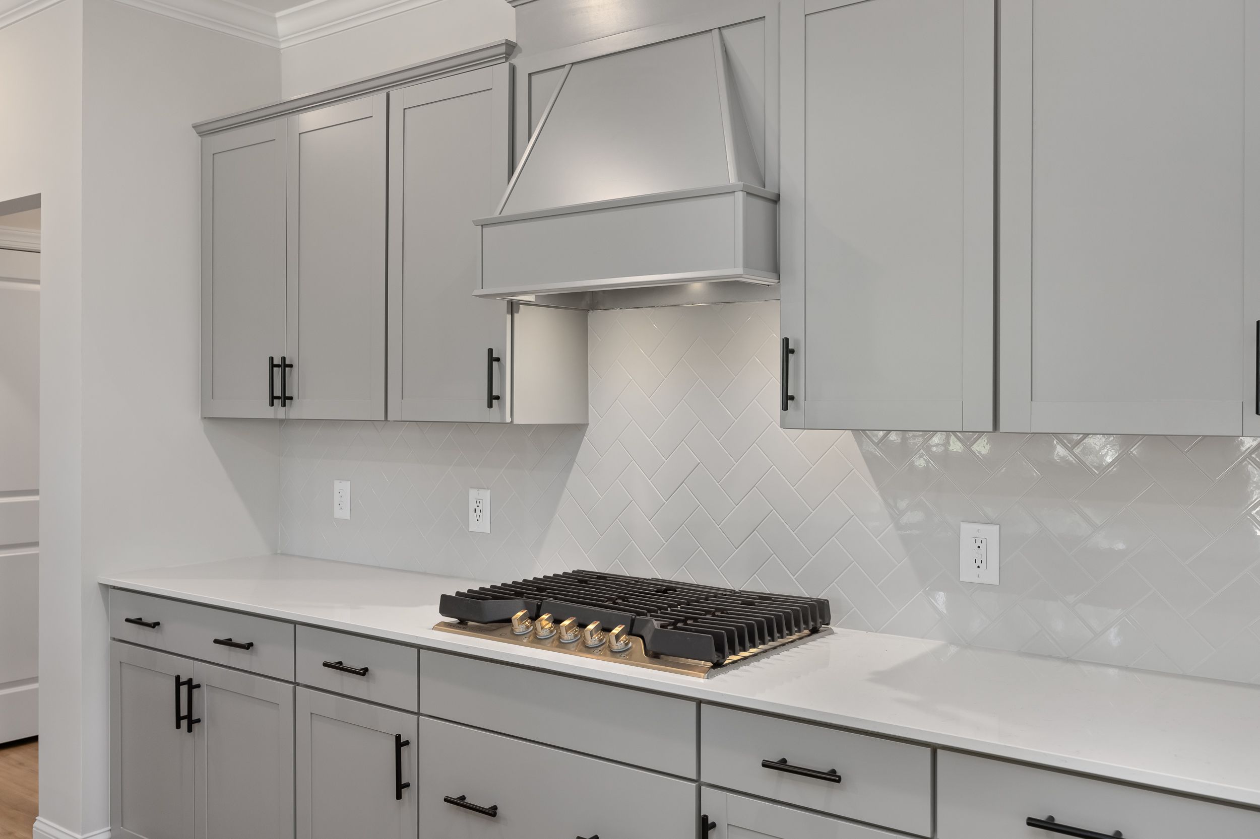 Modern kitchen in The Beech A by Davidson Homes featuring gray shaker cabinets, white quartz counters, and gas range