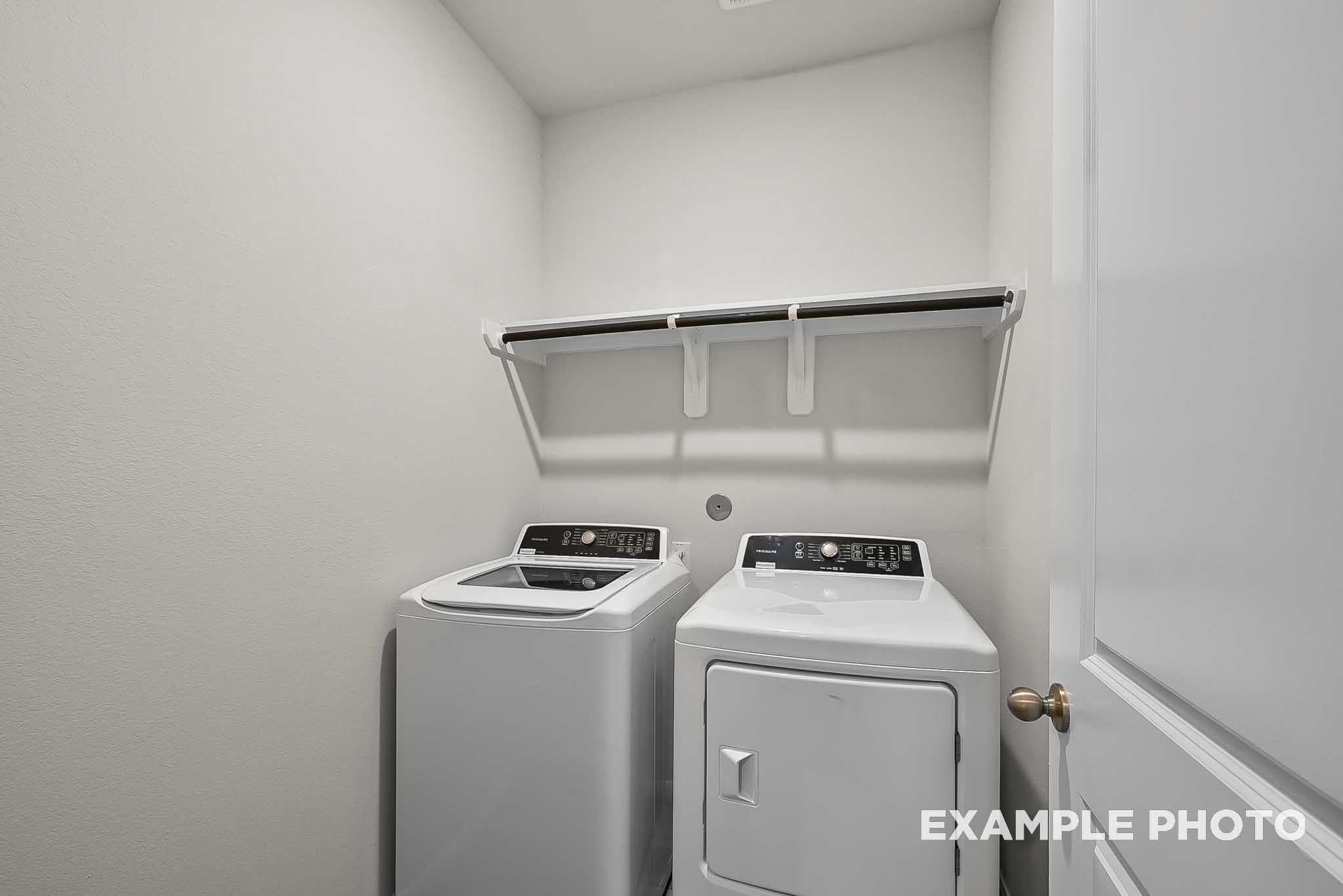 Laundry room with washer and dryer hookups and overhead shelving in The Blanco F floor plan at Spring Branch Crossing.