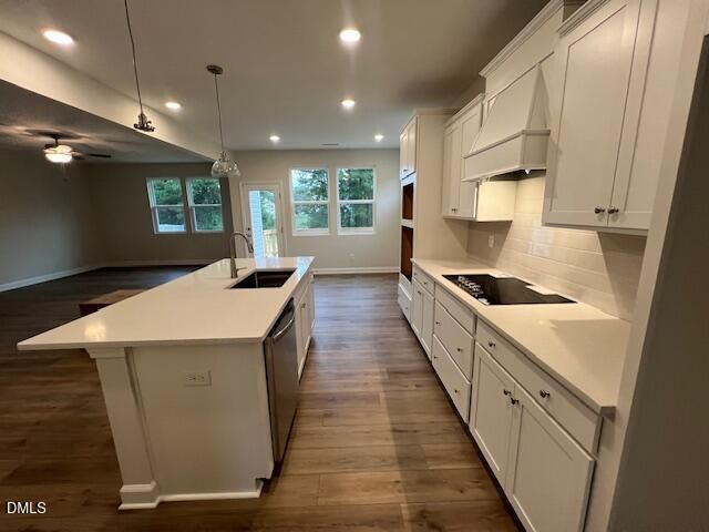 White kitchen with island sink, quartz countertops, and hardwood floors in The Willow D by Davidson Homes, Lillington, NC