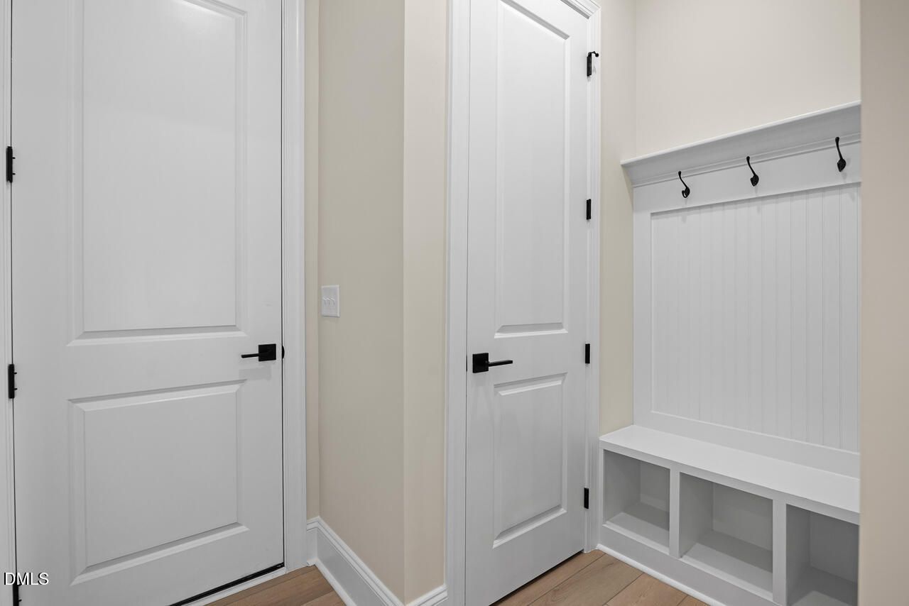 Mudroom with built-in bench, coat hooks, and white doors in Davidson Homes The Crawford D floor plan at Rockport, Wake Forest, NC