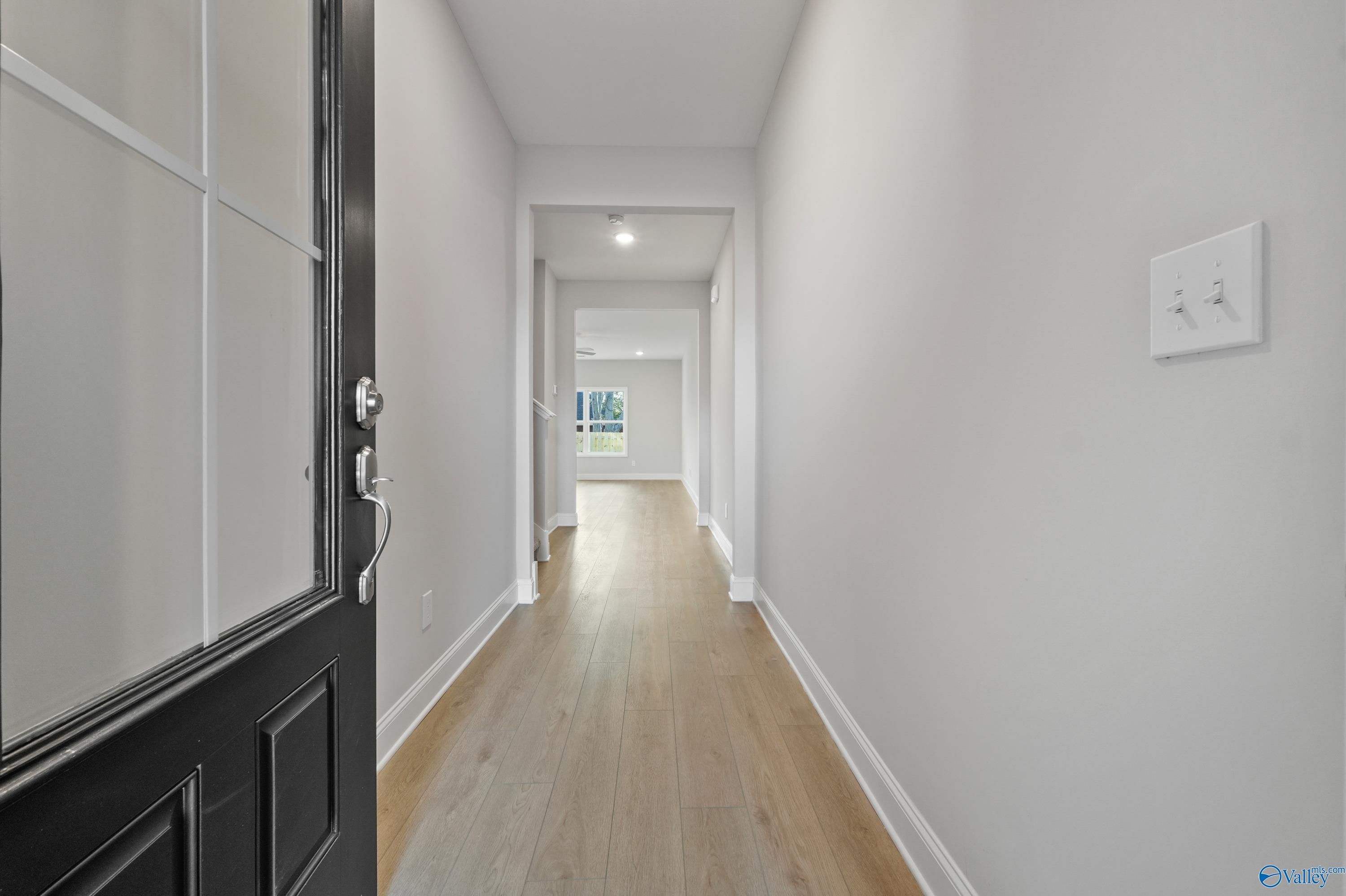Bright open hallway with hardwood floors and white walls in The Camden B by Davidson Homes, Pavilion, Huntsville