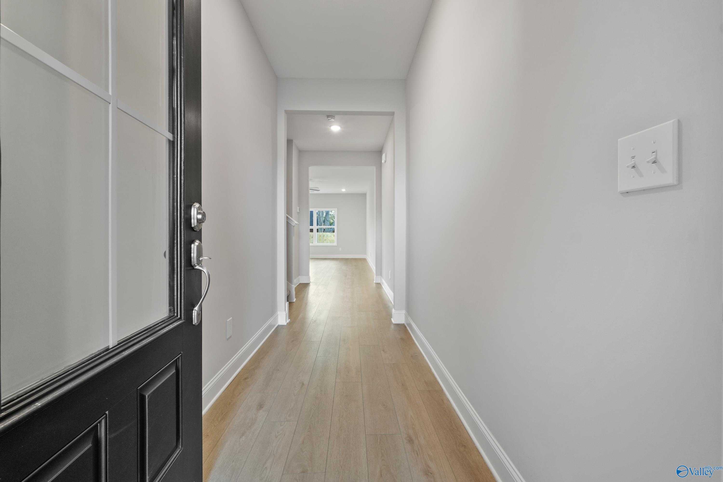 Bright open hallway with hardwood floors and white walls in The Camden B by Davidson Homes, Pavilion, Huntsville