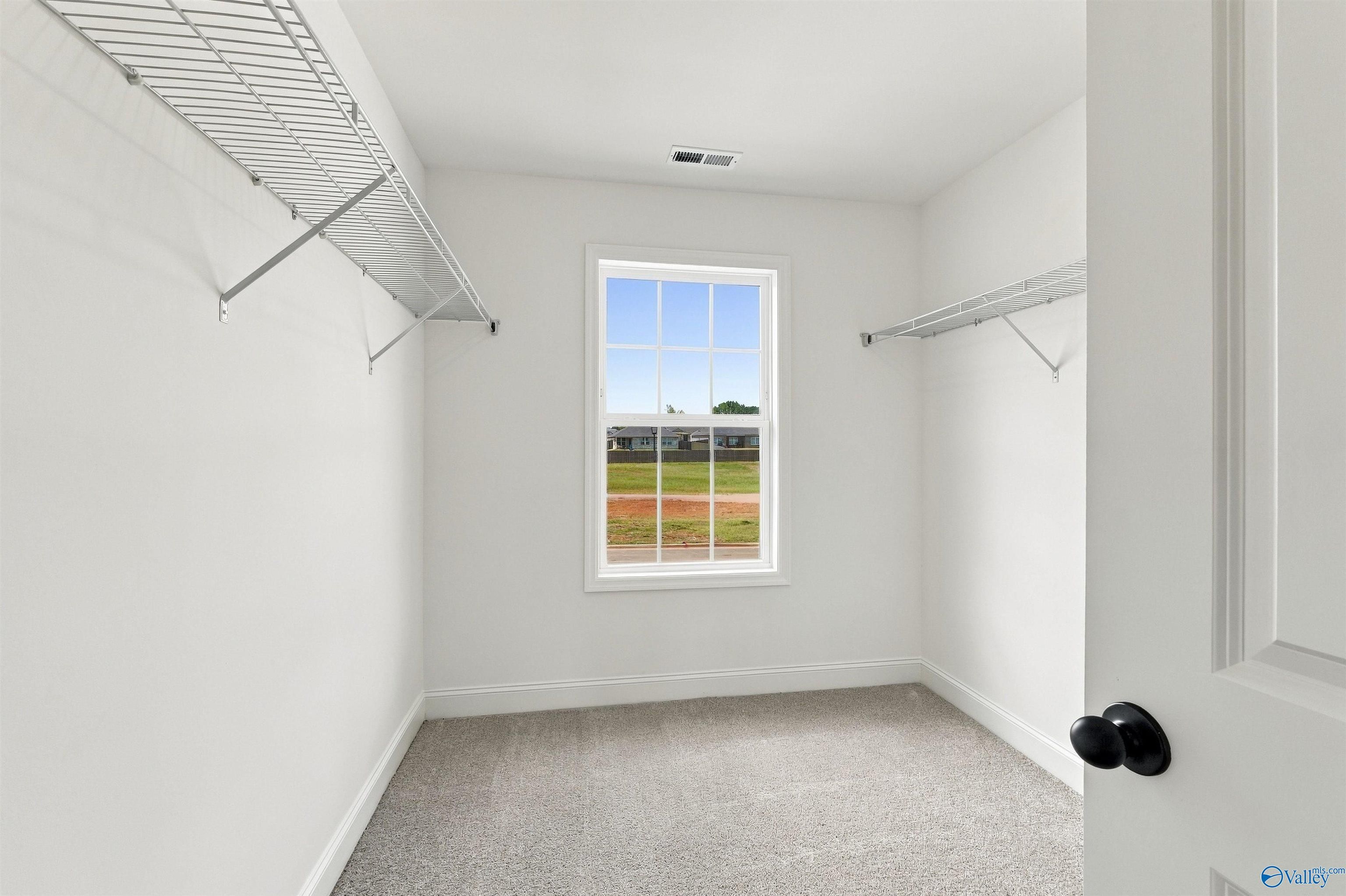 Walk-in closet with wire shelving and natural light in Davidson Homes The Shelby A, The Meadows, Athens, Alabama
