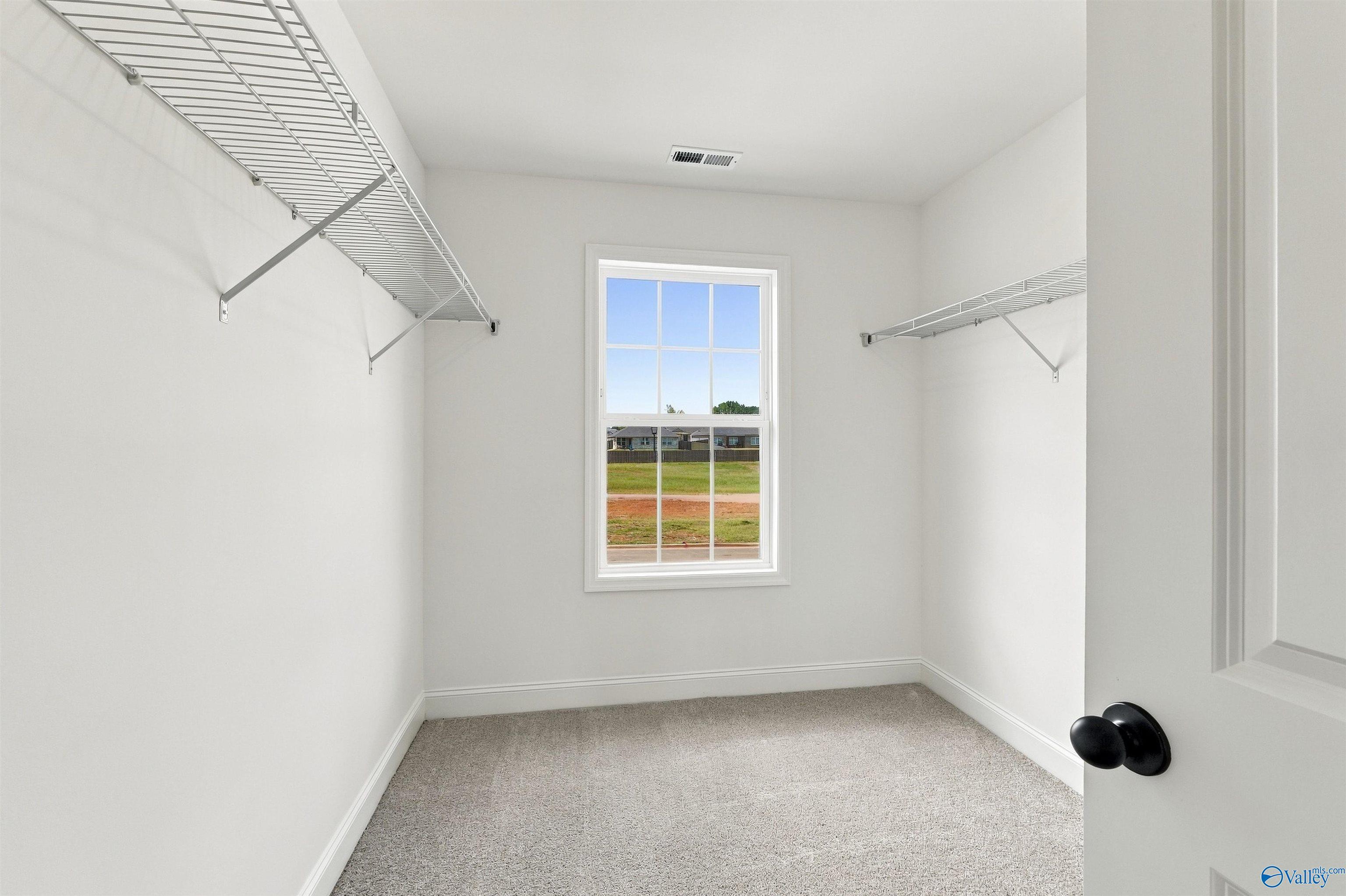 Walk-in closet with wire shelving and natural light in Davidson Homes The Shelby A, The Meadows, Athens, Alabama
