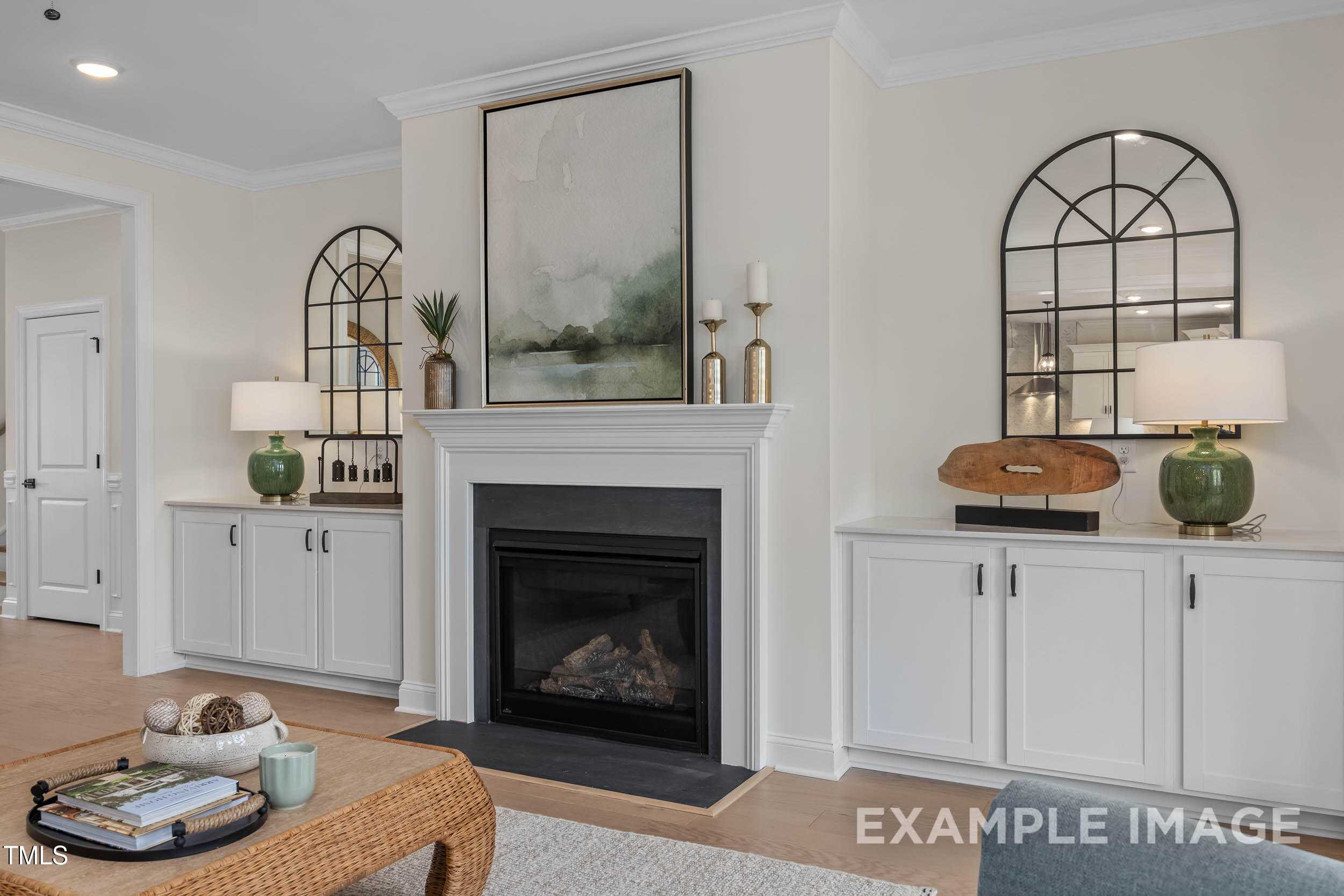 Elegant living room with gas fireplace, arched mirrors, abstract art in Davidson Homes The Crawford B, Raleigh, NC