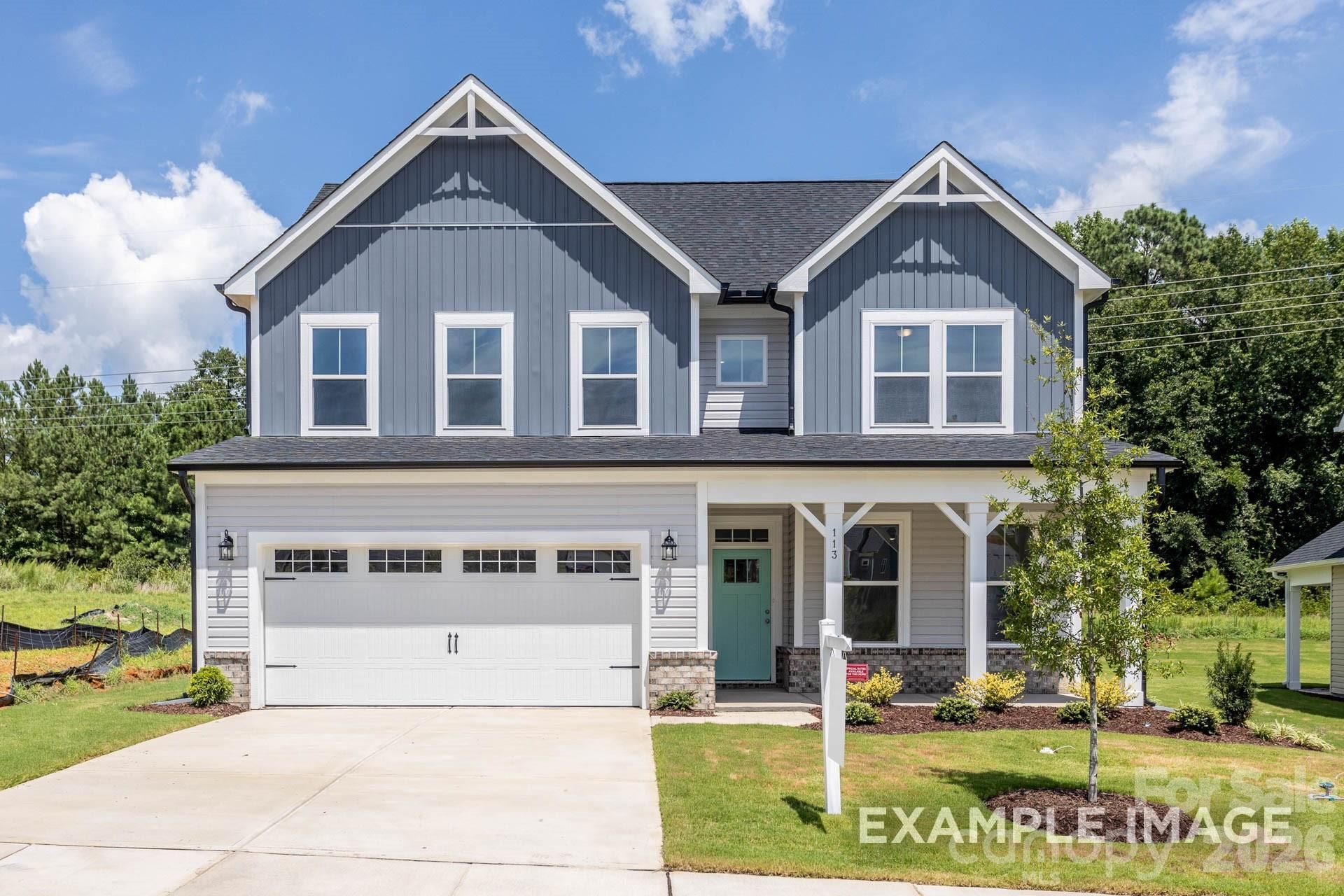 Two-story gray farmhouse-style home with covered front porch and 2-car garage at Windgate, Mooresville, NC by Davidson Homes