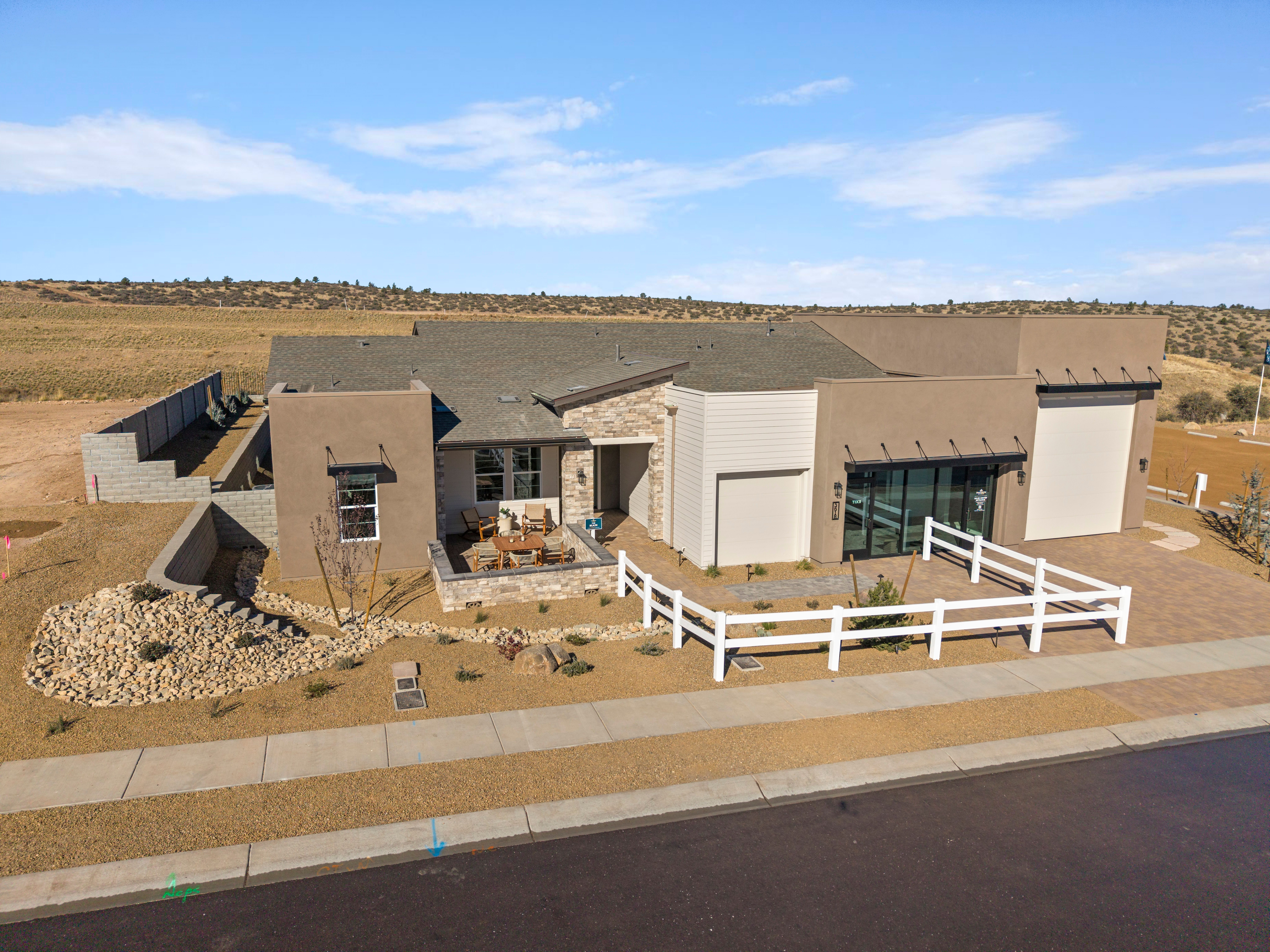 Contemporary stucco home at Hidden Hills in Prescott AZ with flat roof garage patio and rock desert landscaping by Davidson Homes