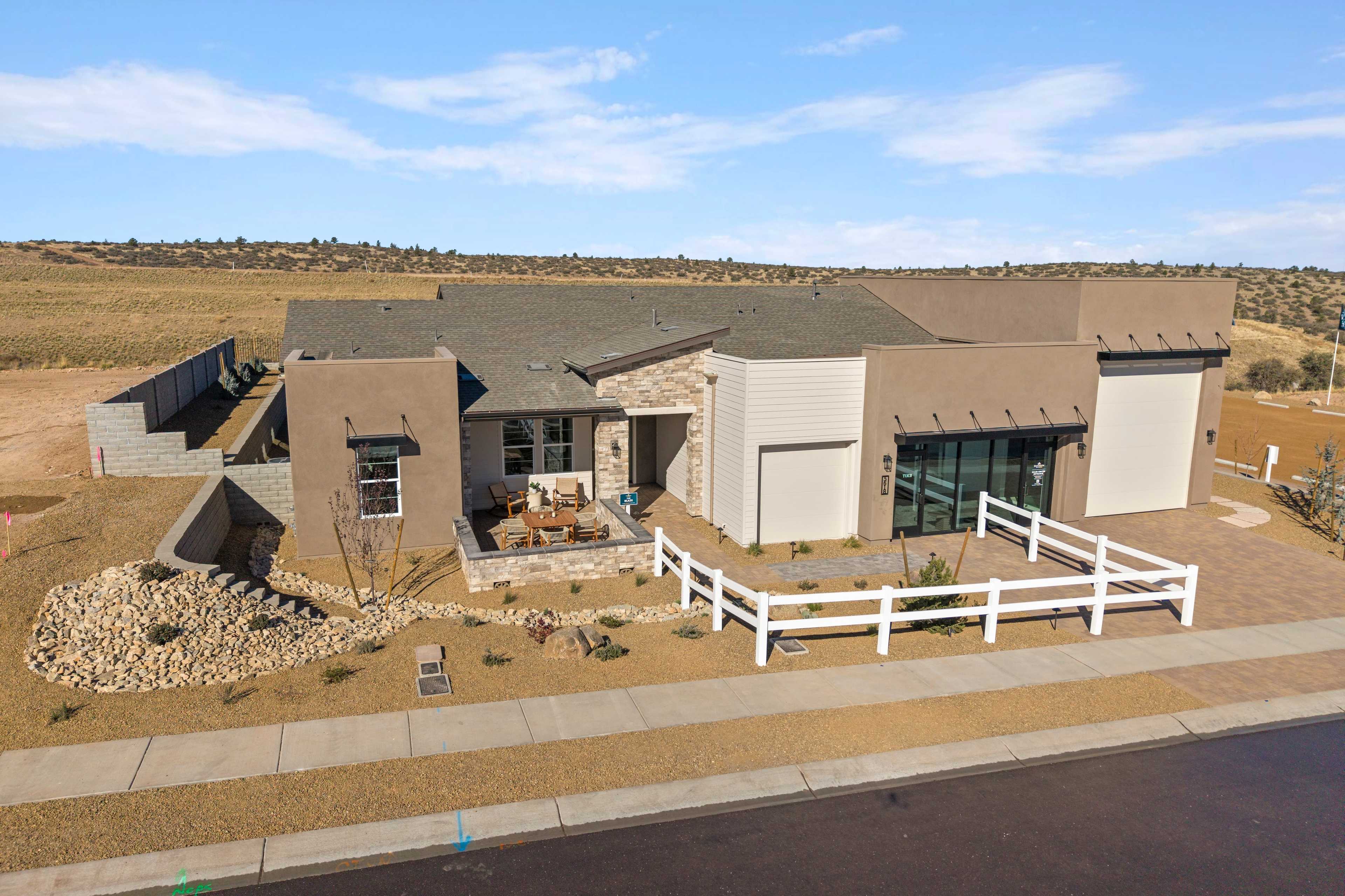 Contemporary stucco home at Hidden Hills in Prescott AZ with flat roof garage patio and rock desert landscaping by Davidson Homes