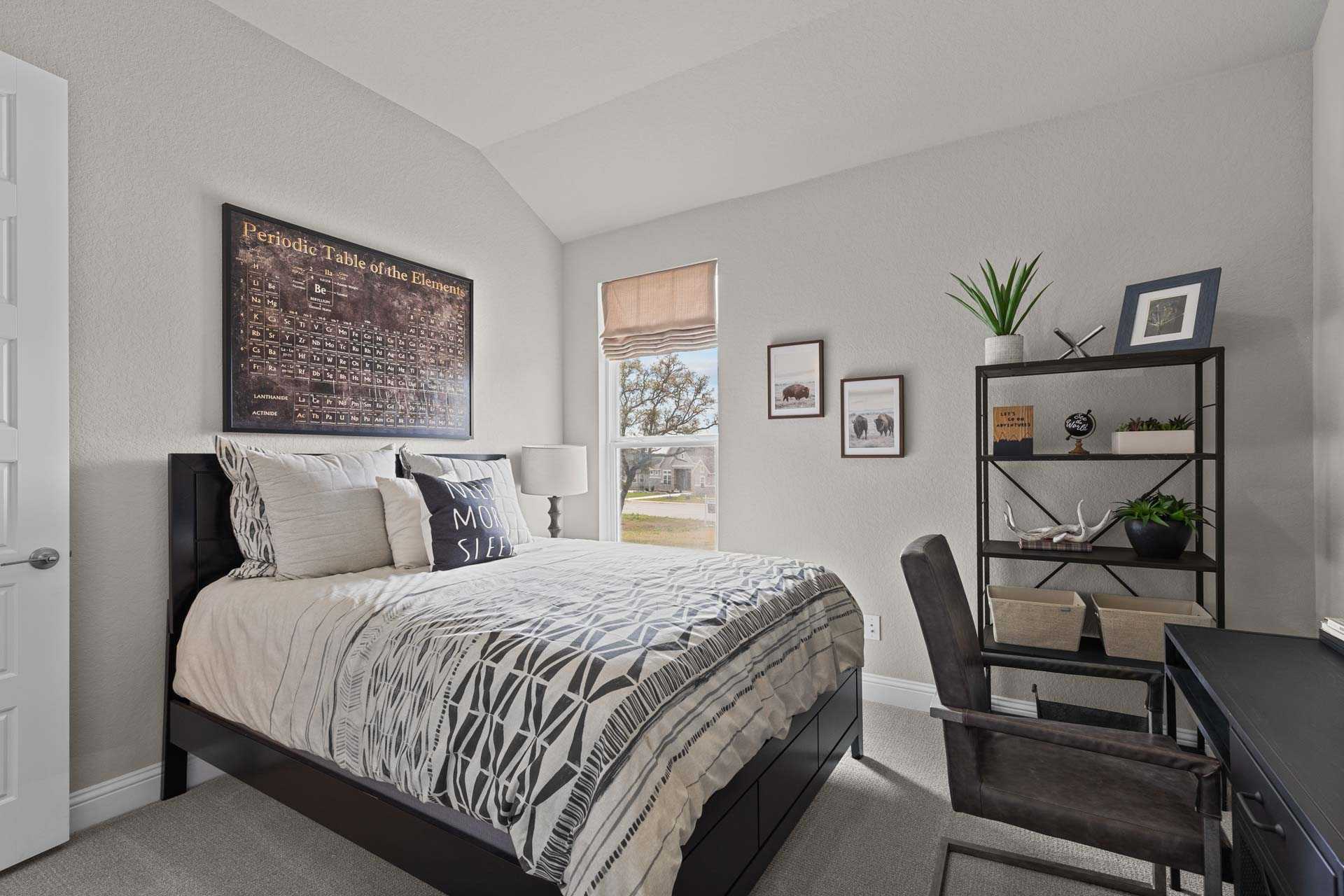 Spacious master bedroom in The Garner A with king bed, modern desk, framed art, and window blinds