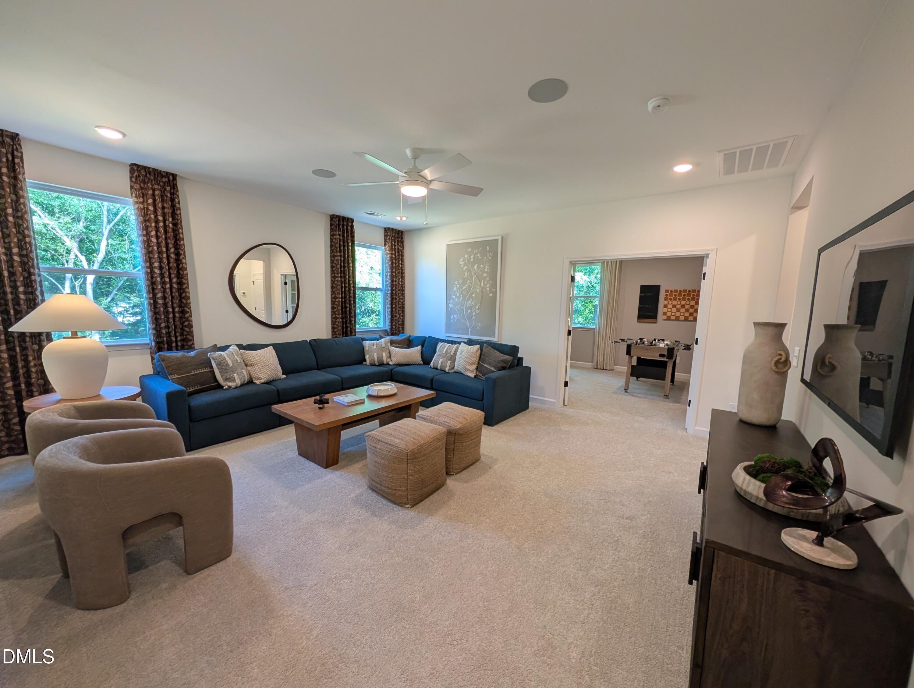 Spacious living room with blue sectional in The Aspen B floor plan at Wendell Ridge, Wendell, North Carolina.