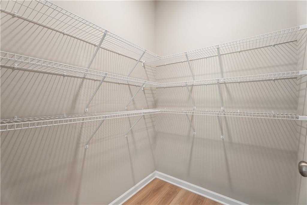 Spacious corner walk-in closet with white wire shelving on three walls in The Bartlett by Davidson Homes, Phenix City, Alabama