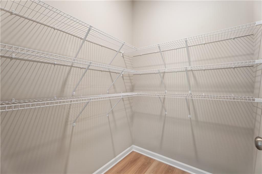 Spacious corner walk-in closet with white wire shelving on three walls in The Bartlett by Davidson Homes, Phenix City, Alabama