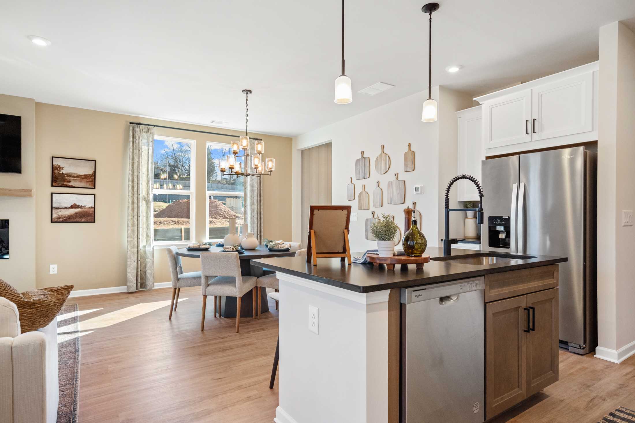 Open-concept kitchen dining in The Marion A Davidson Homes featuring large island, stainless appliances, chandelier, and adjacent living space