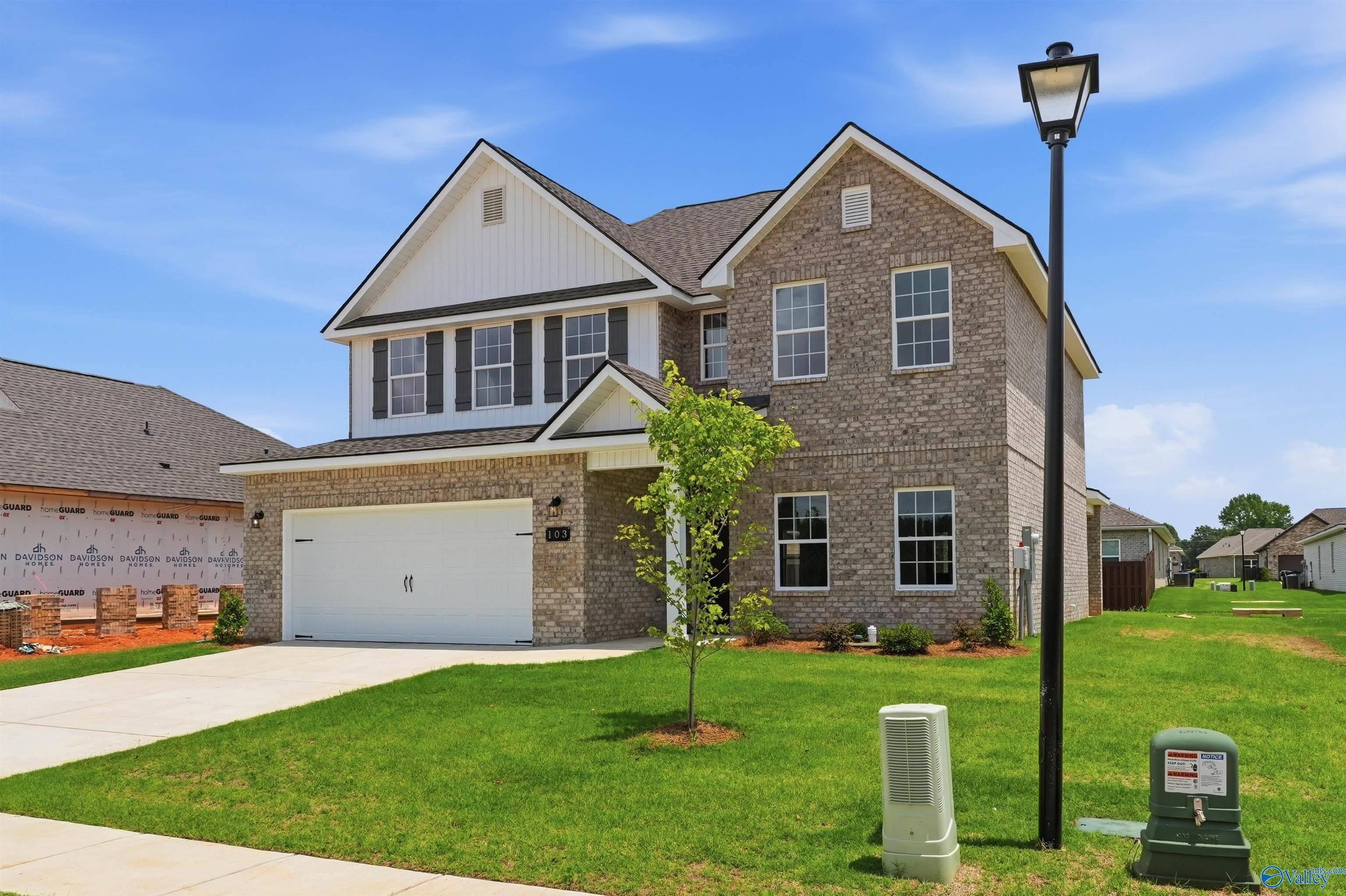 Two-story Shelby A floor plan home by Davidson Homes with brick exterior and two-car garage in Wood Trail, Toney, Alabama.