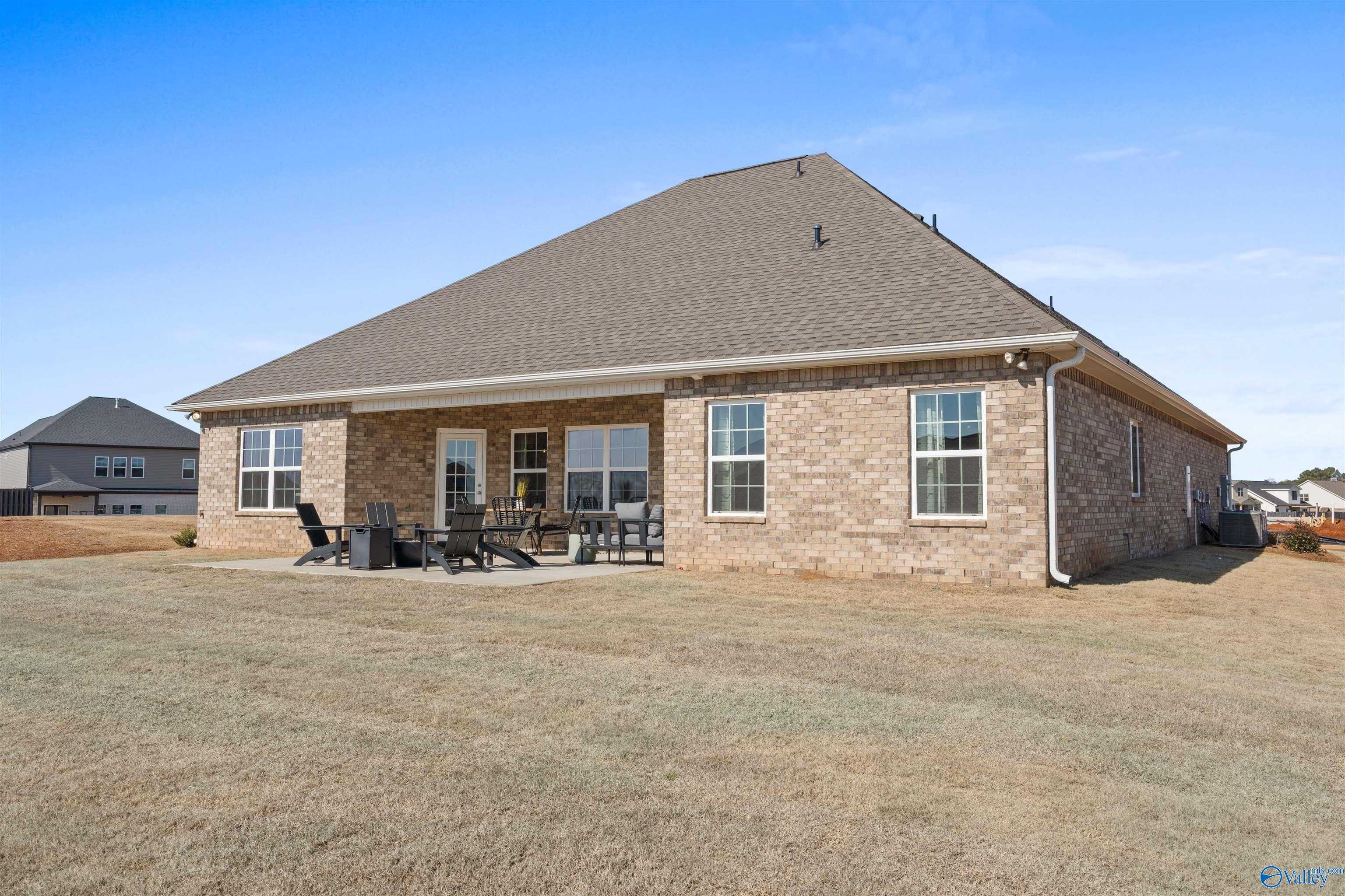 Covered back patio with outdoor seating on brick single-story home, The Rockford B with Bonus by Davidson Homes in Madison, Alabama