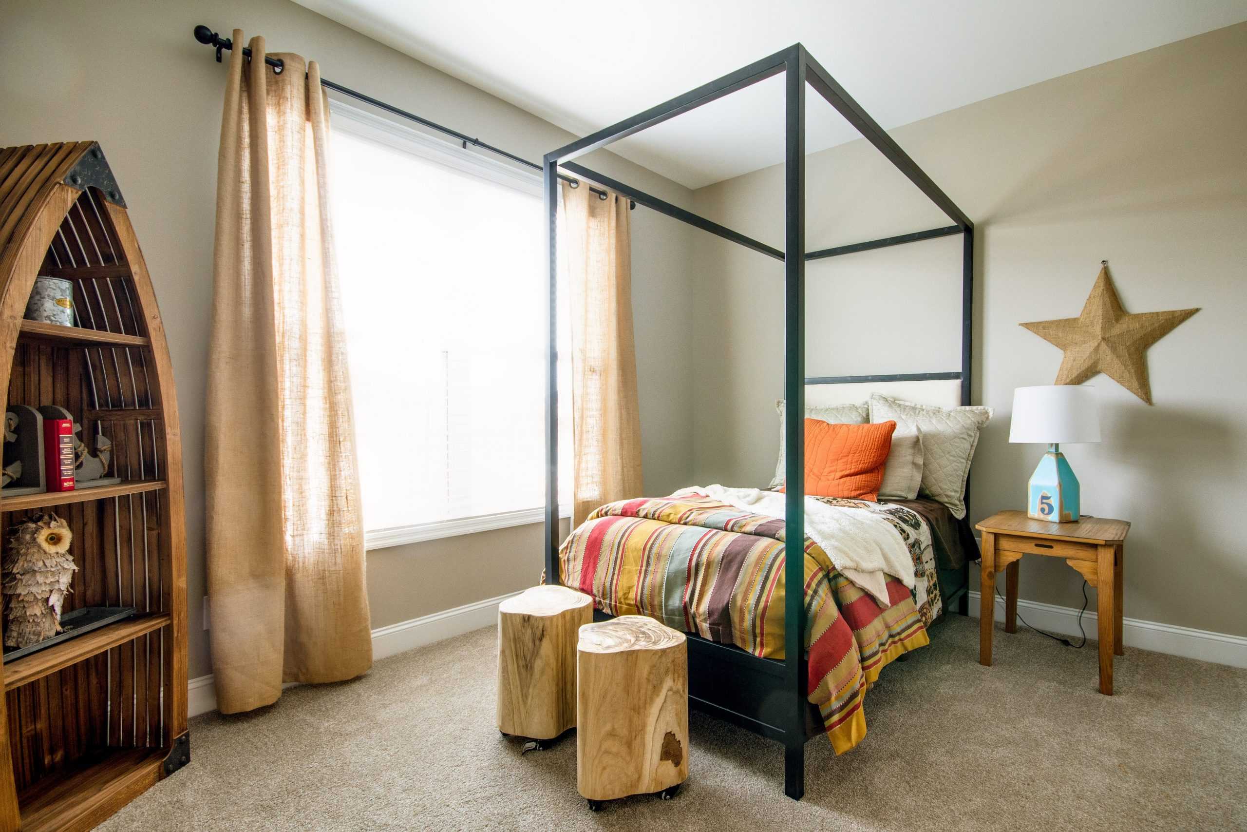 Cozy child's bedroom at Bakers Farm in Priceville Alabama with metal frame bed, colorful plaid bedding, nautical bookshelf, and star decor
