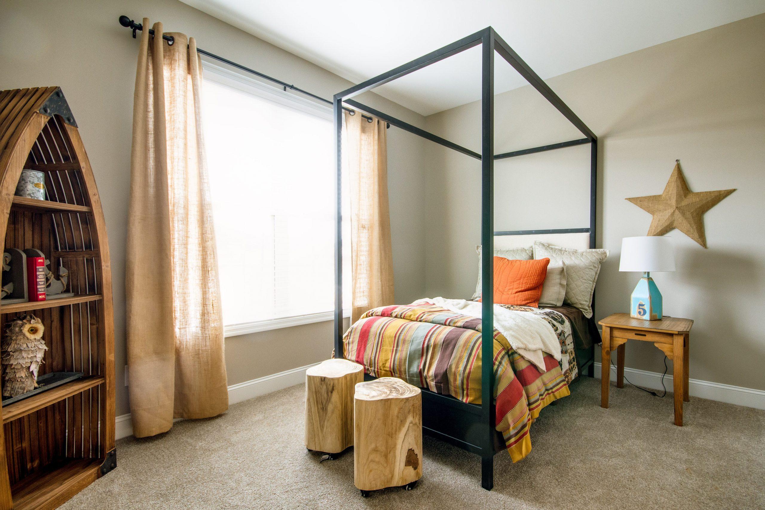 Cozy child's bedroom at Bakers Farm in Priceville Alabama with metal frame bed, colorful plaid bedding, nautical bookshelf, and star decor