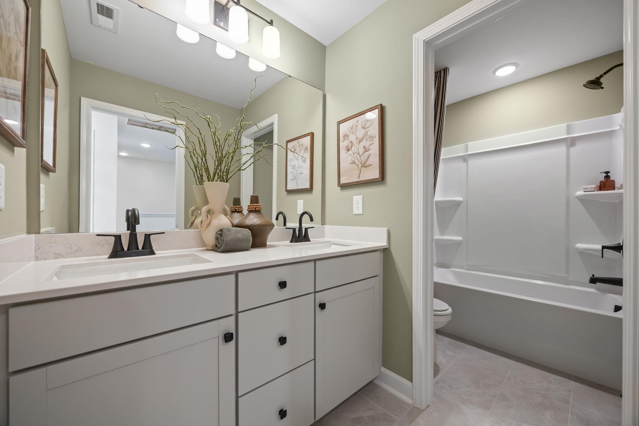 Spacious bathroom at Forestville Yard Townhomes in Knightdale NC with double gray vanity, soaking tub, and greige walls