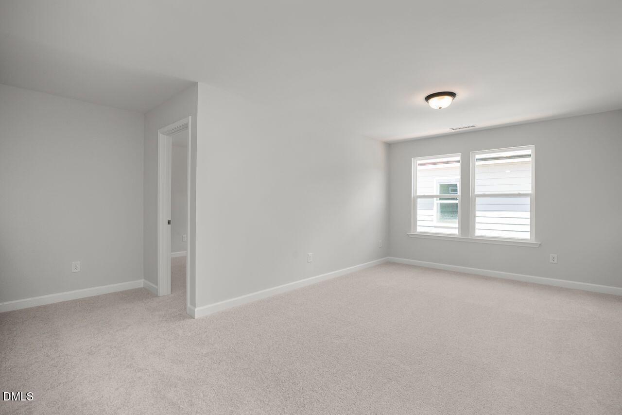 Spacious, light-filled bedroom with neutral carpet in The Birch II A floor plan at Montrose in Aberdeen, North Carolina.