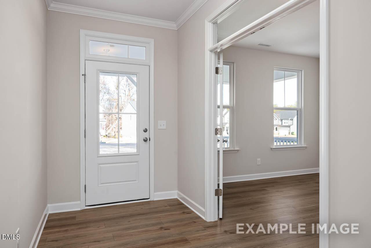Bright foyer entrance with glass-paneled front door and French doors in The Hickory II B home at Montrose, Aberdeen, NC.