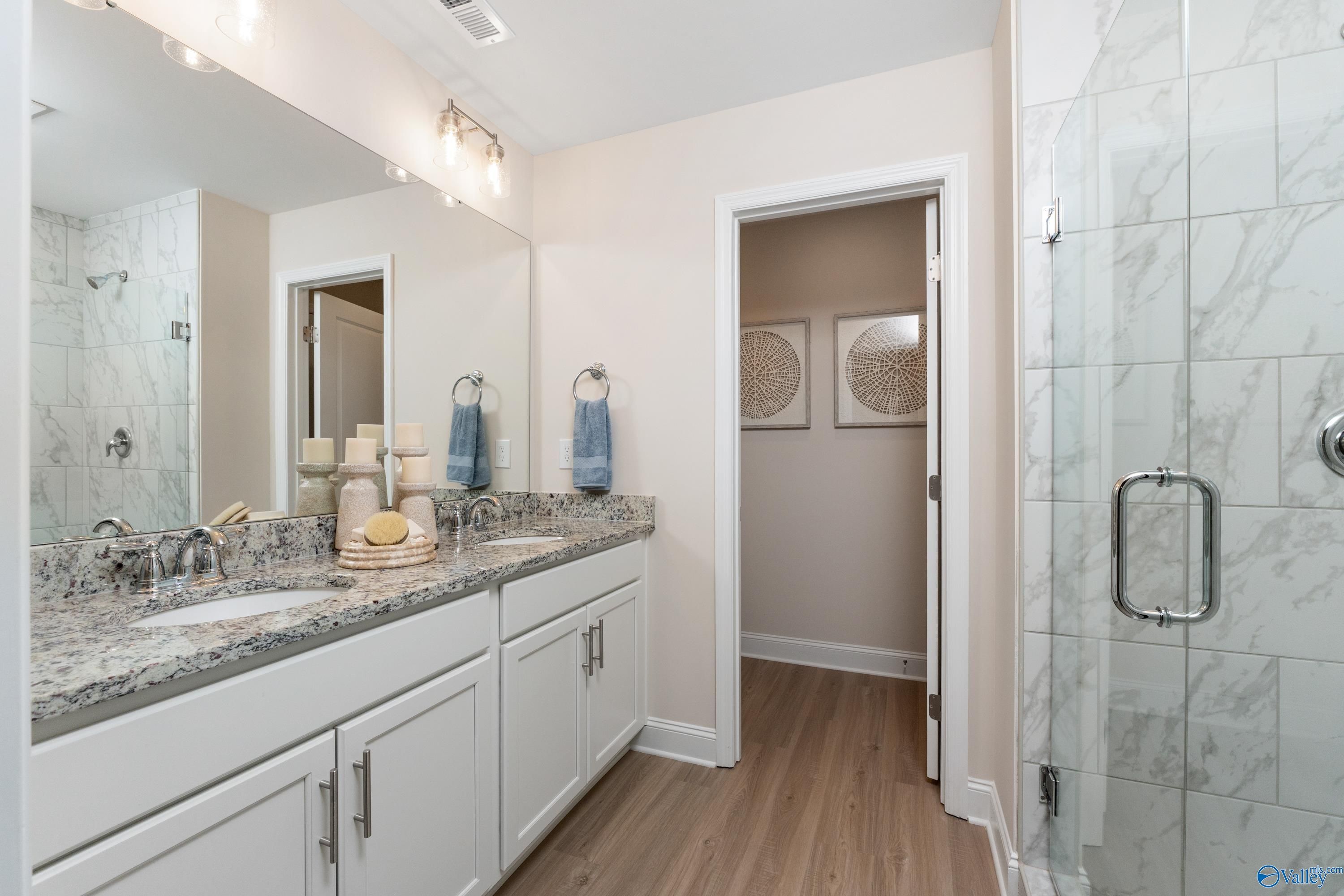Modern master bathroom with double vanity, quartz counters, and glass shower in Davidson Homes The Camden, Huntsville AL