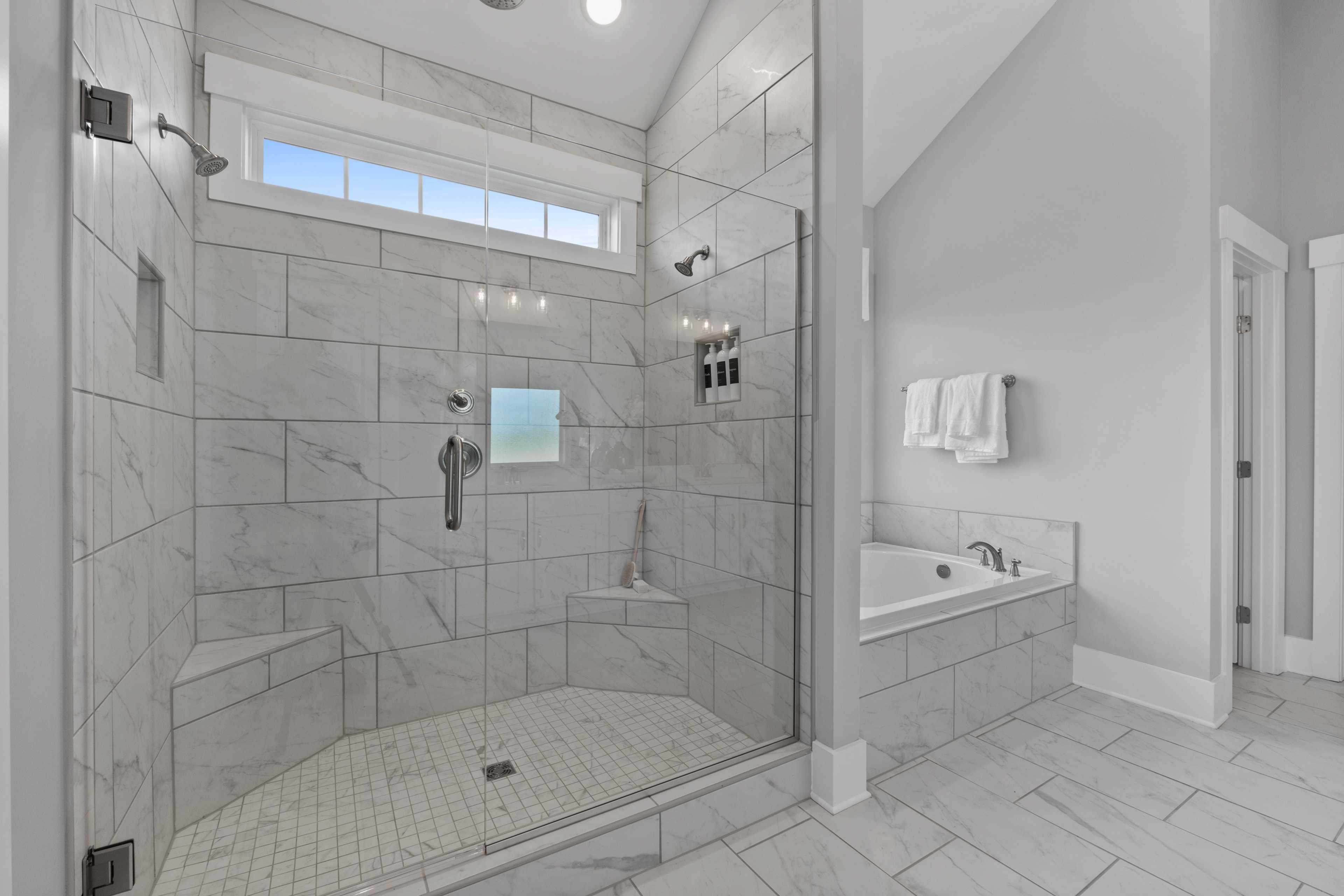 Luxurious master bathroom at Creekside in Harvest Alabama with walk-in glass shower, freestanding tub, subway tile walls