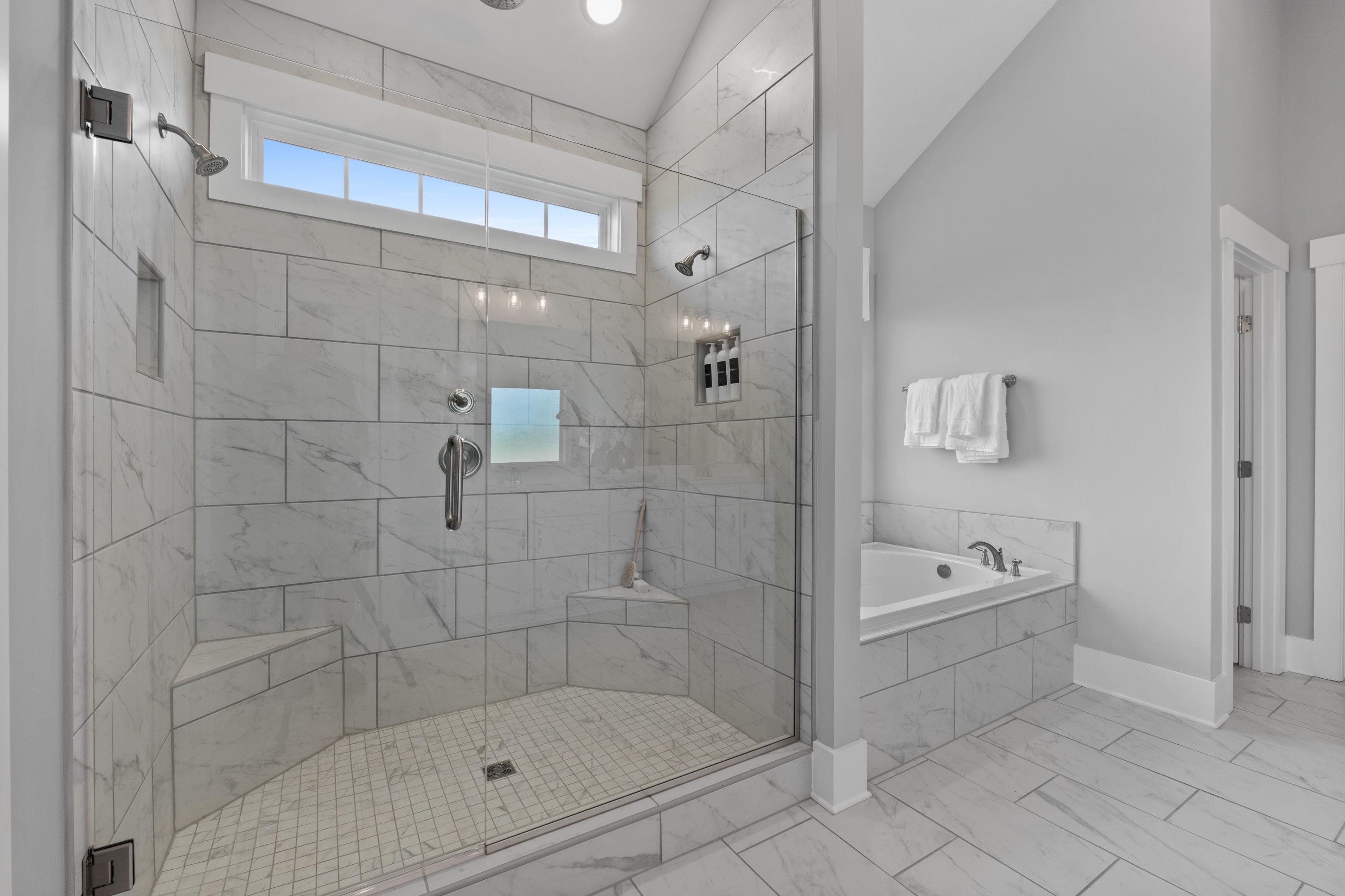 Luxurious master bathroom at Creekside in Harvest Alabama with walk-in glass shower, freestanding tub, subway tile walls