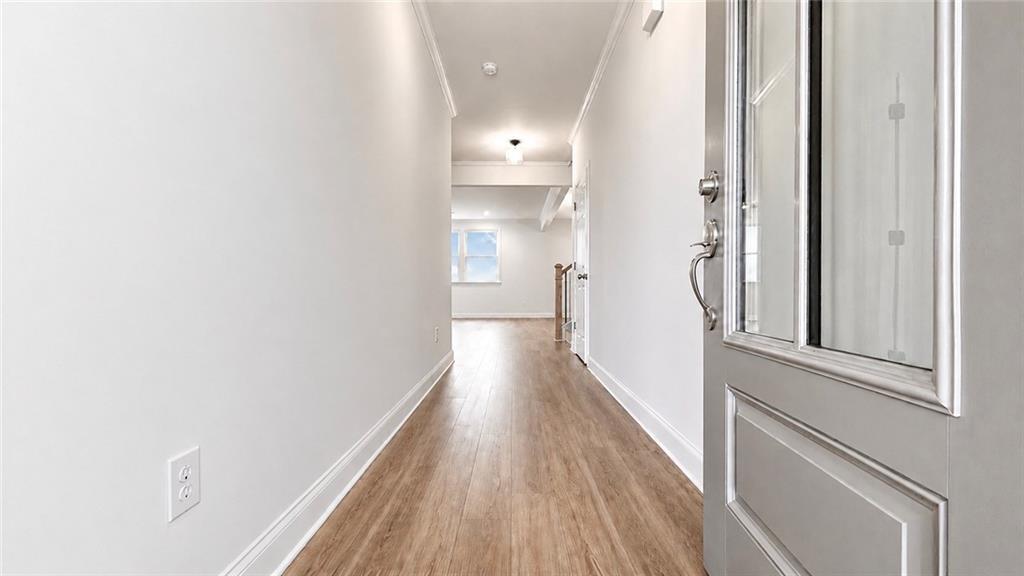 Bright foyer entrance with wood-look flooring in The Hickory C floor plan by Davidson Homes in Wehunt Meadows, Hoschton.