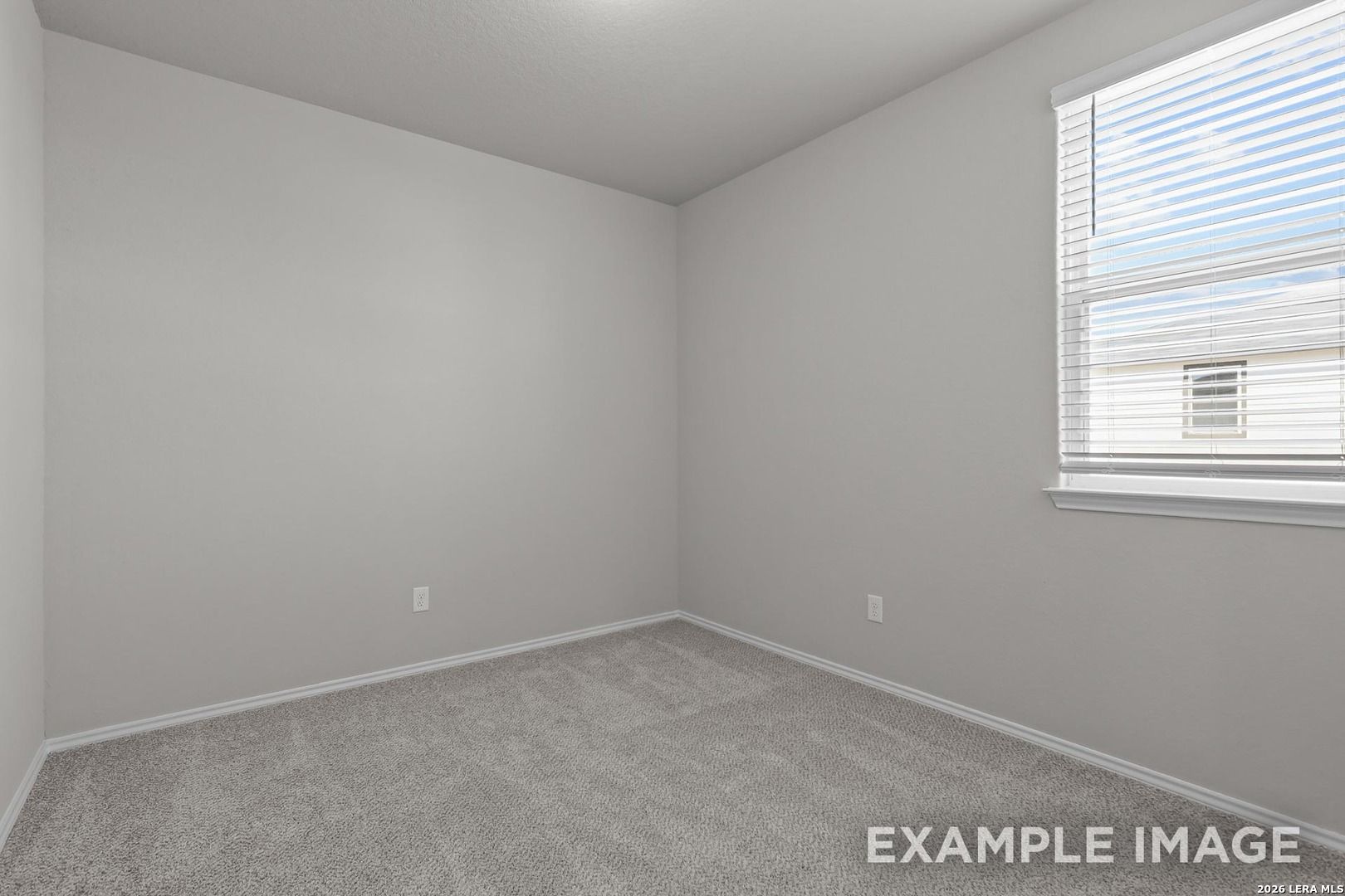 Bright empty bedroom with light gray walls, carpet flooring, and large window in Davidson Homes The Colorado D, San Antonio