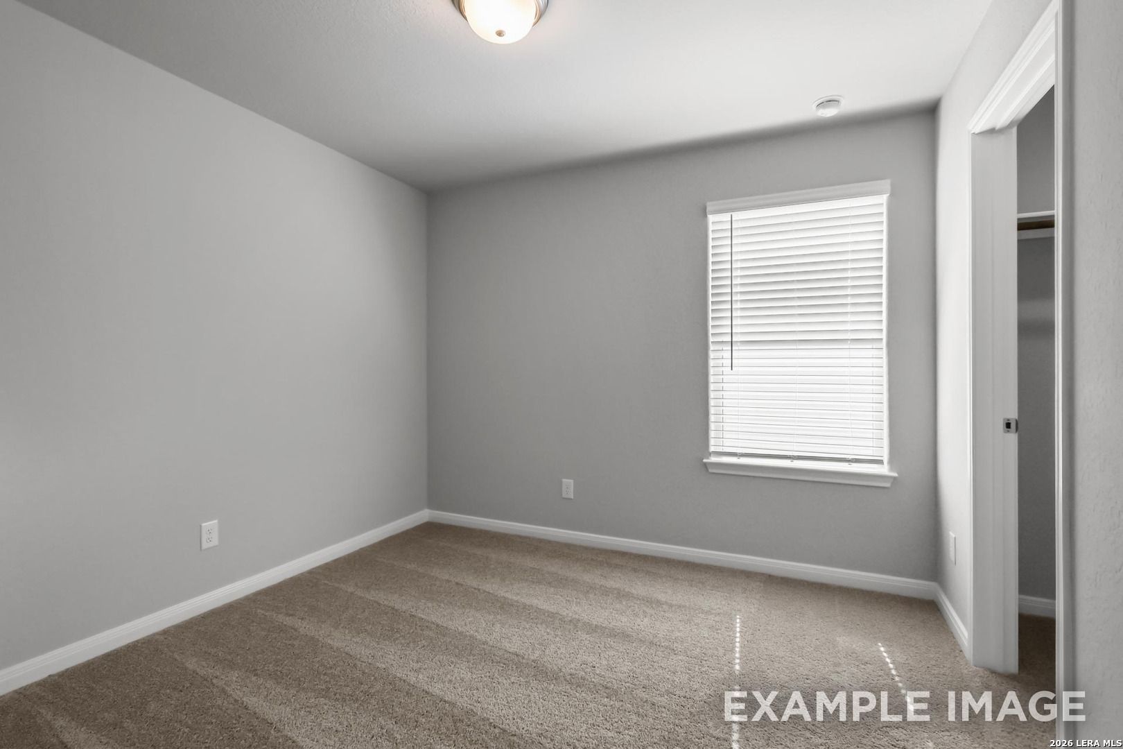 Spacious secondary bedroom with neutral carpet and walk-in closet in The Gillian A floor plan, Cedar Heights, San Antonio.