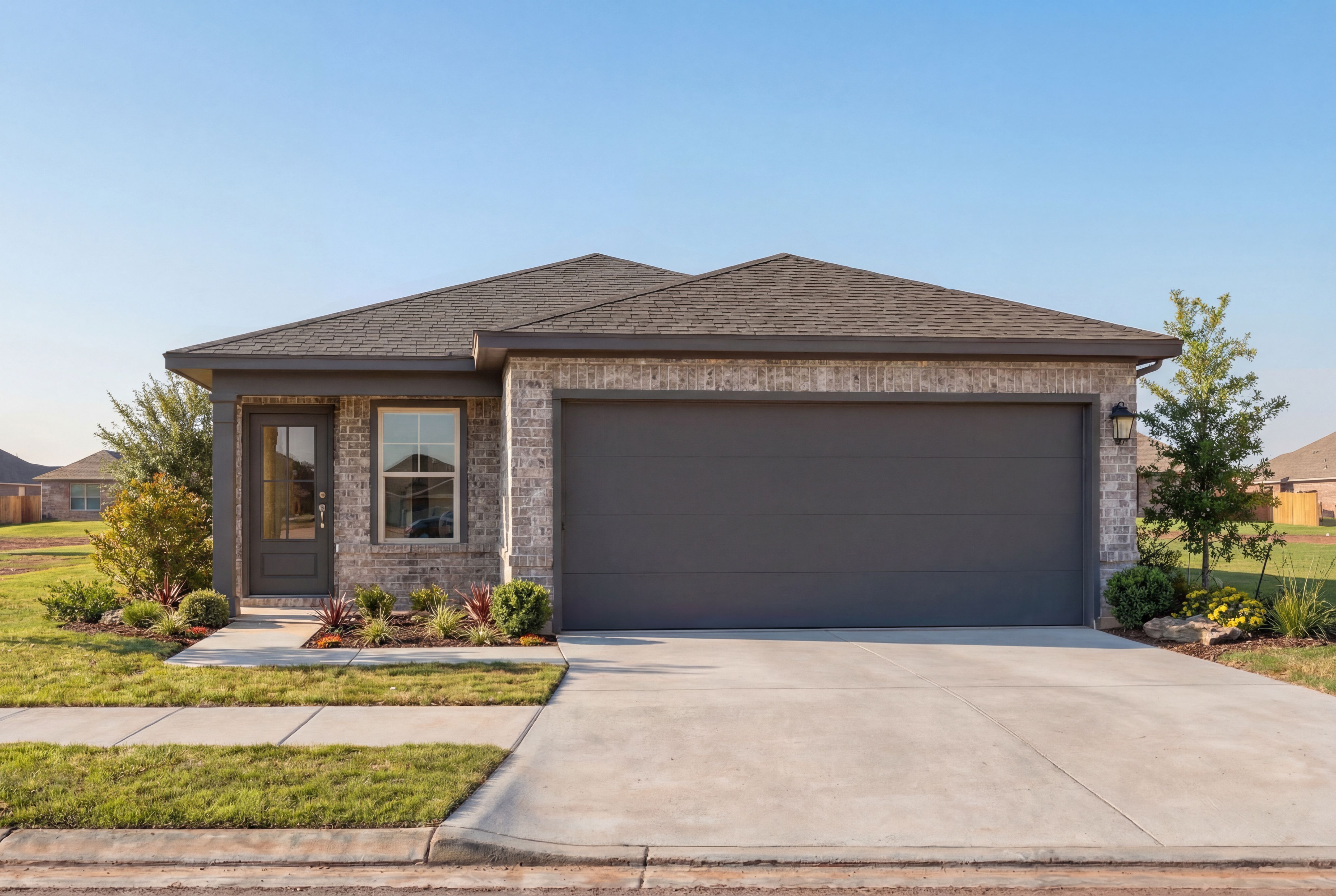 Front elevation of The Colorado F single-story home with brick accents, gray garage, and landscaped yard in Magnolia, Texas
