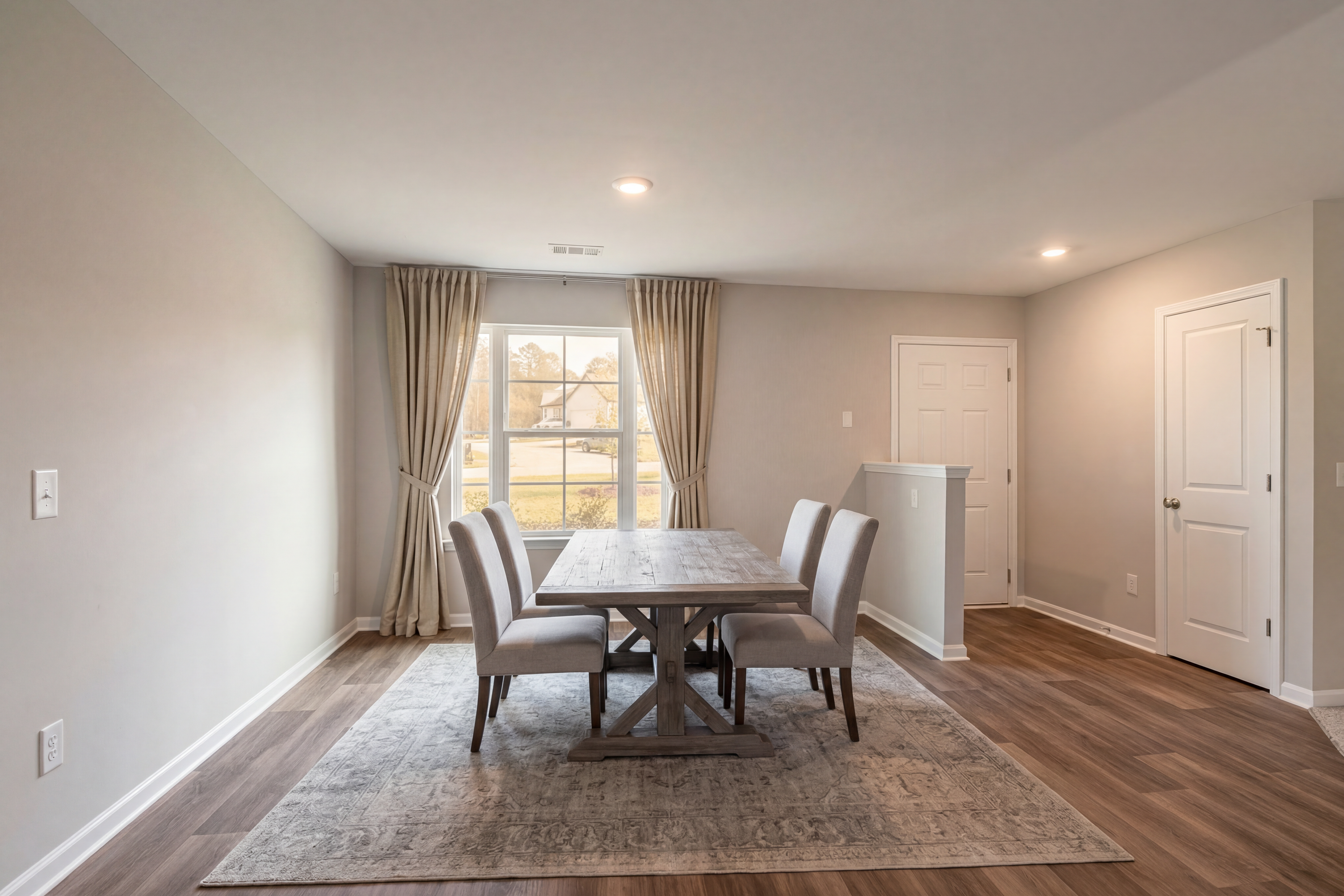 Spacious dining room in Summer Vineyard, Phenix City AL featuring rustic wooden table, upholstered chairs, neutral walls, and large window