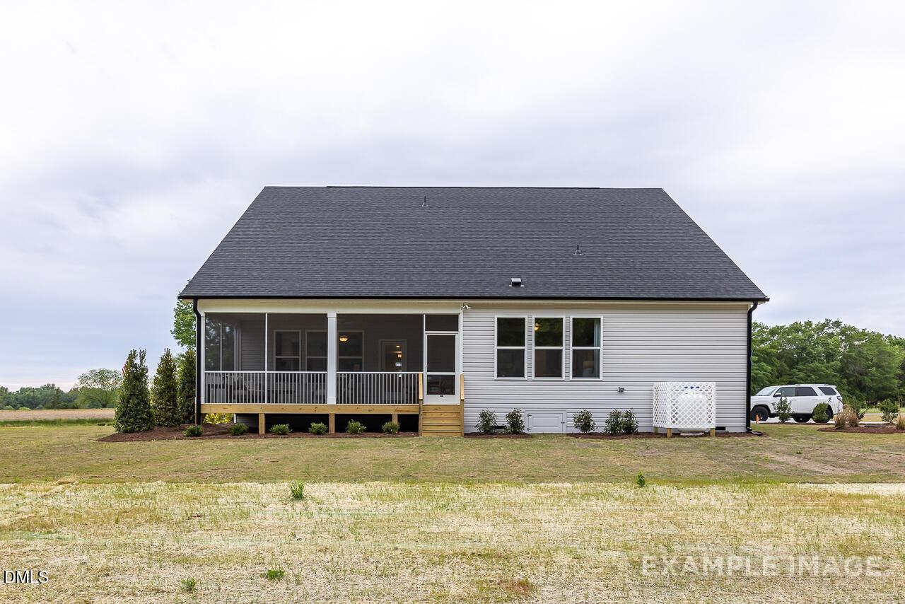 Screened back porch and wooden deck on white-sided The Magnolia B home by Davidson Homes in Tobacco Road, Angier, NC