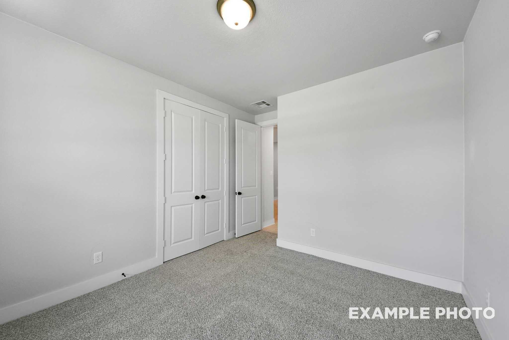 Bright secondary bedroom with walk-in closet doors and en-suite bath in Davidson Homes The George A, Lago Mar, Texas City
