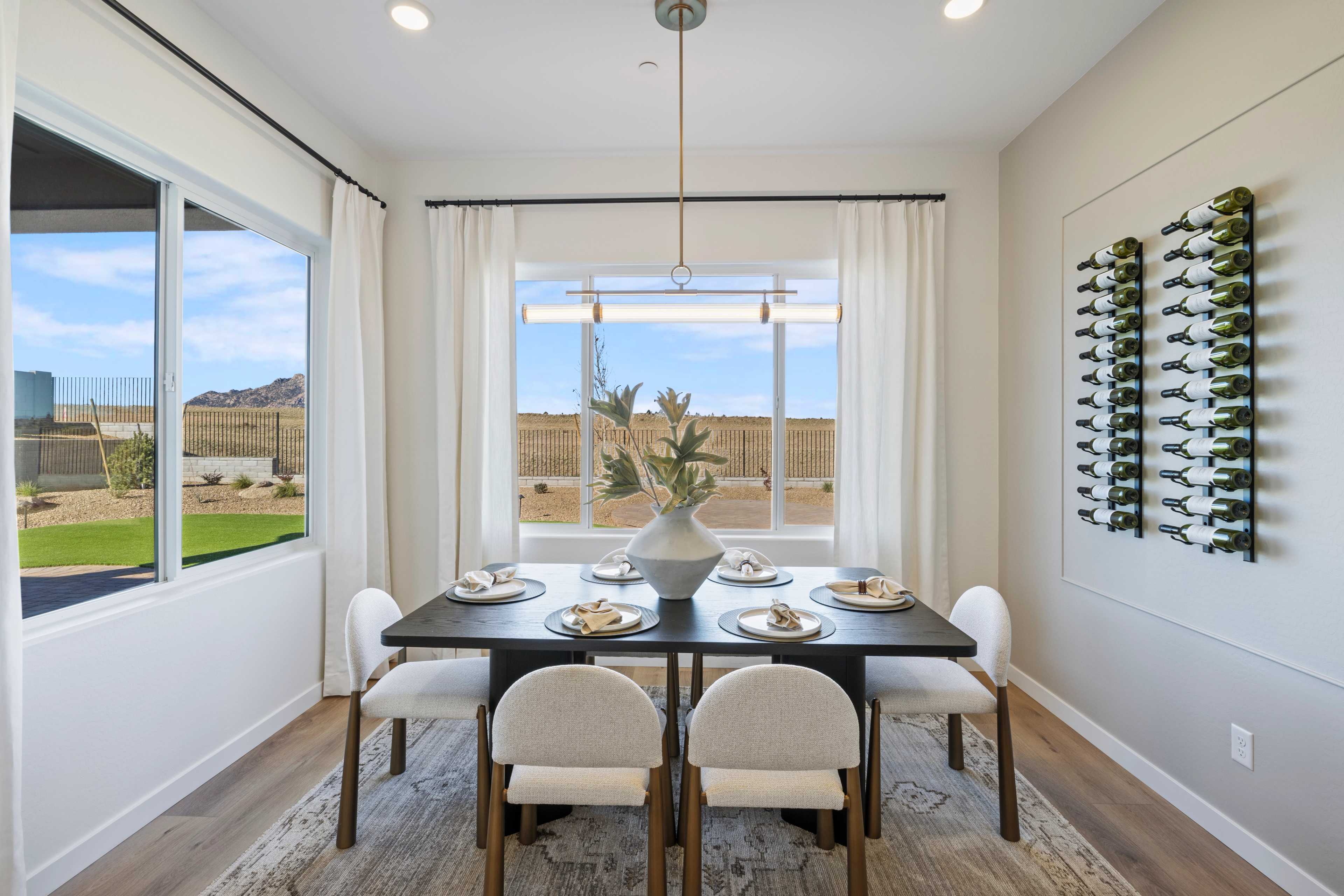 Elegant dining room in Hidden Hills Prescott AZ by Davidson Homes with set table, wine rack, and desert landscape window
