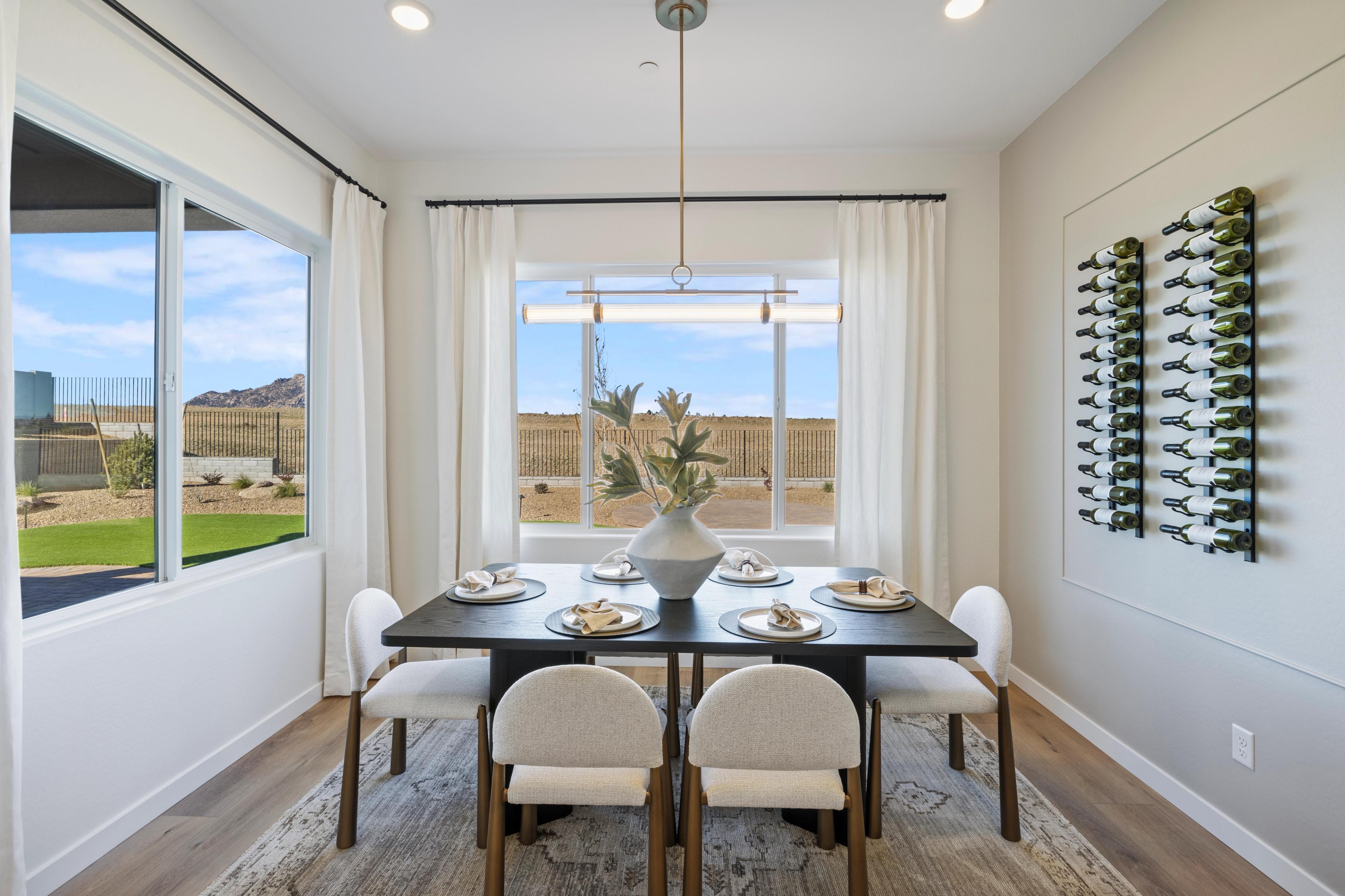 Elegant dining room in Hidden Hills Prescott AZ by Davidson Homes with set table, wine rack, and desert landscape window