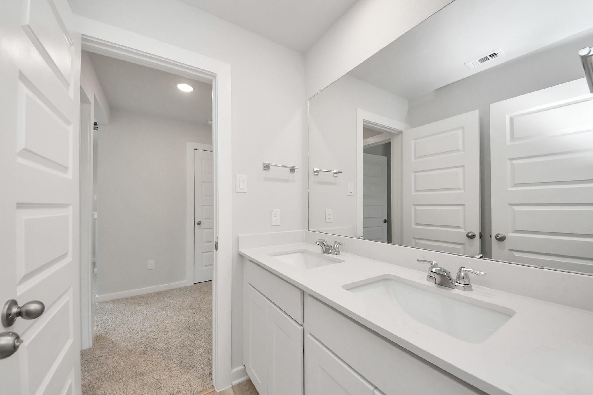 Modern double vanity bathroom with white cabinets in The Sabine F floor plan at Liberty Estates, Cleveland, Texas.