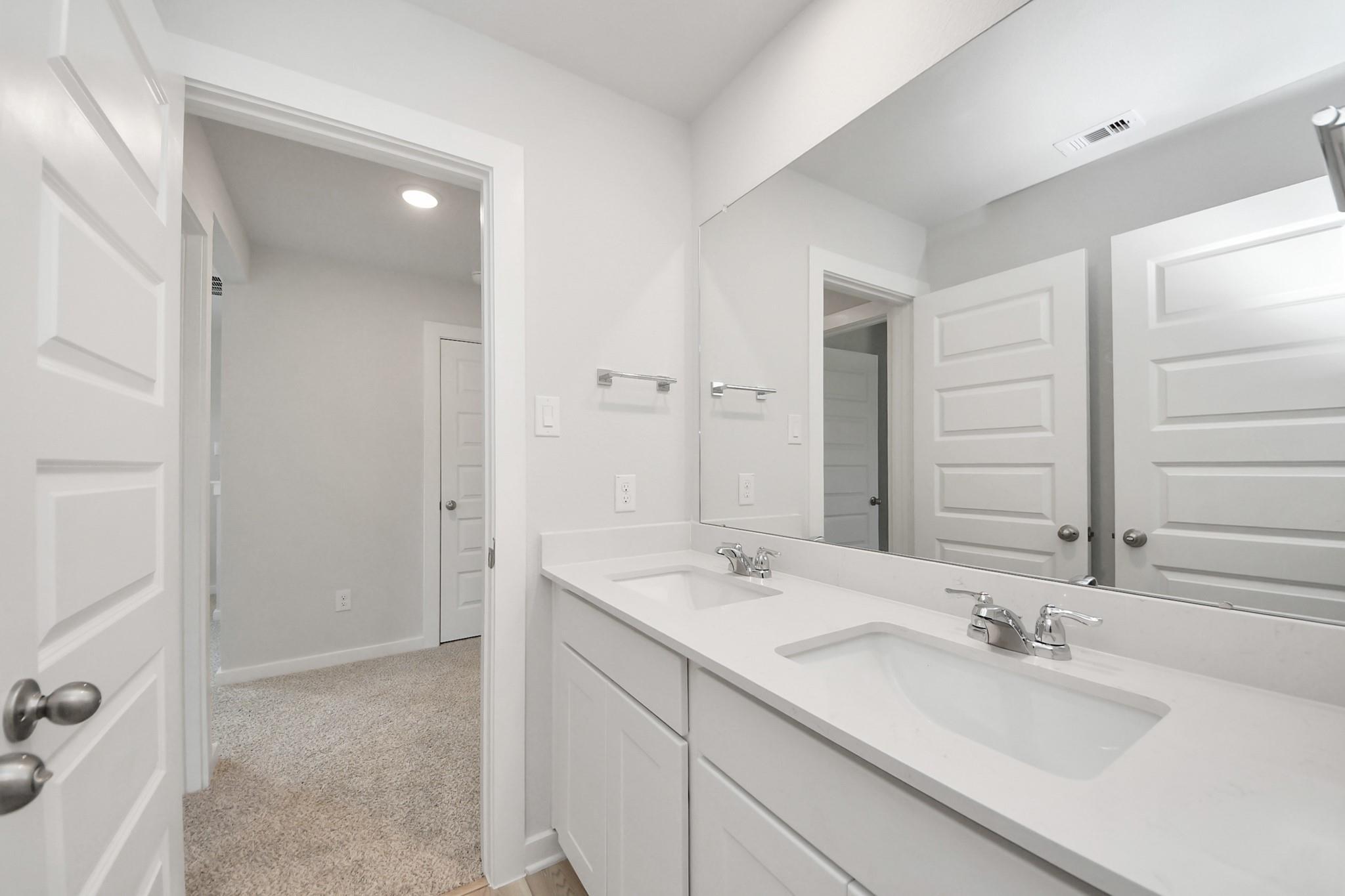 Modern double vanity bathroom with white cabinets in The Sabine F floor plan at Liberty Estates, Cleveland, Texas.