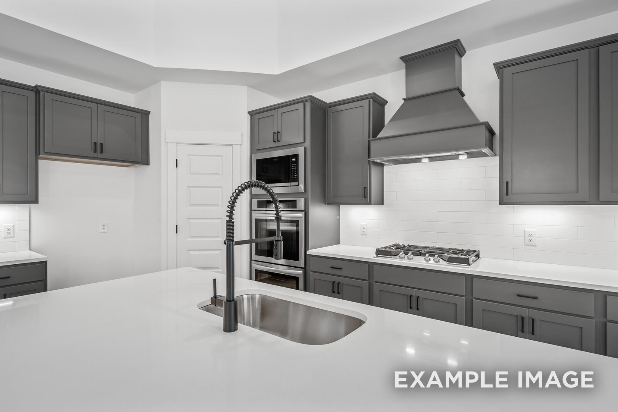 Modern kitchen with gray shaker cabinets, white quartz counters, stainless appliances in Davidson Homes The Ridgeport C, Gallatin, TN