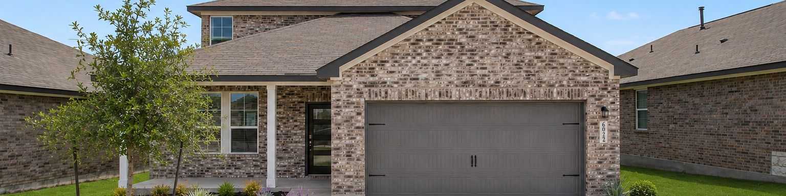 Davidson Homes exterior with brick facade and two-car garage at Comanche Ridge in San Antonio, Texas.