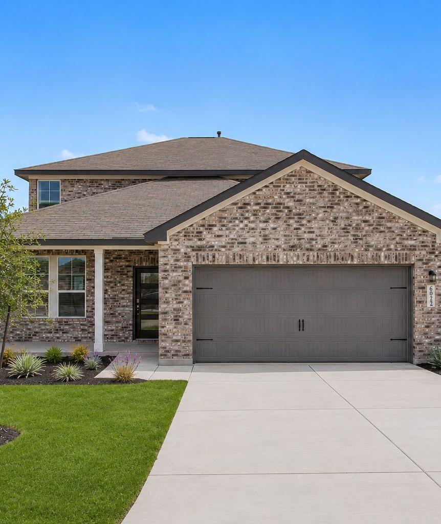 Davidson Homes exterior with brick facade and two-car garage at Comanche Ridge in San Antonio, Texas.