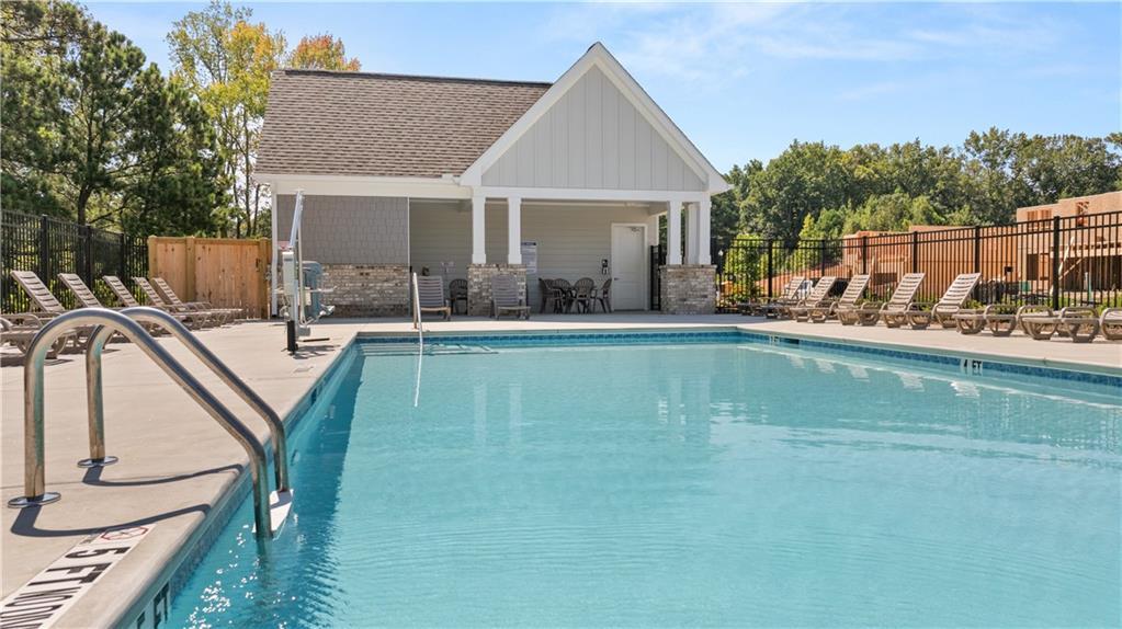 Community swimming pool with lounge chairs and pool house pavilion at Lake Shore by Davidson Homes in Winder, Georgia